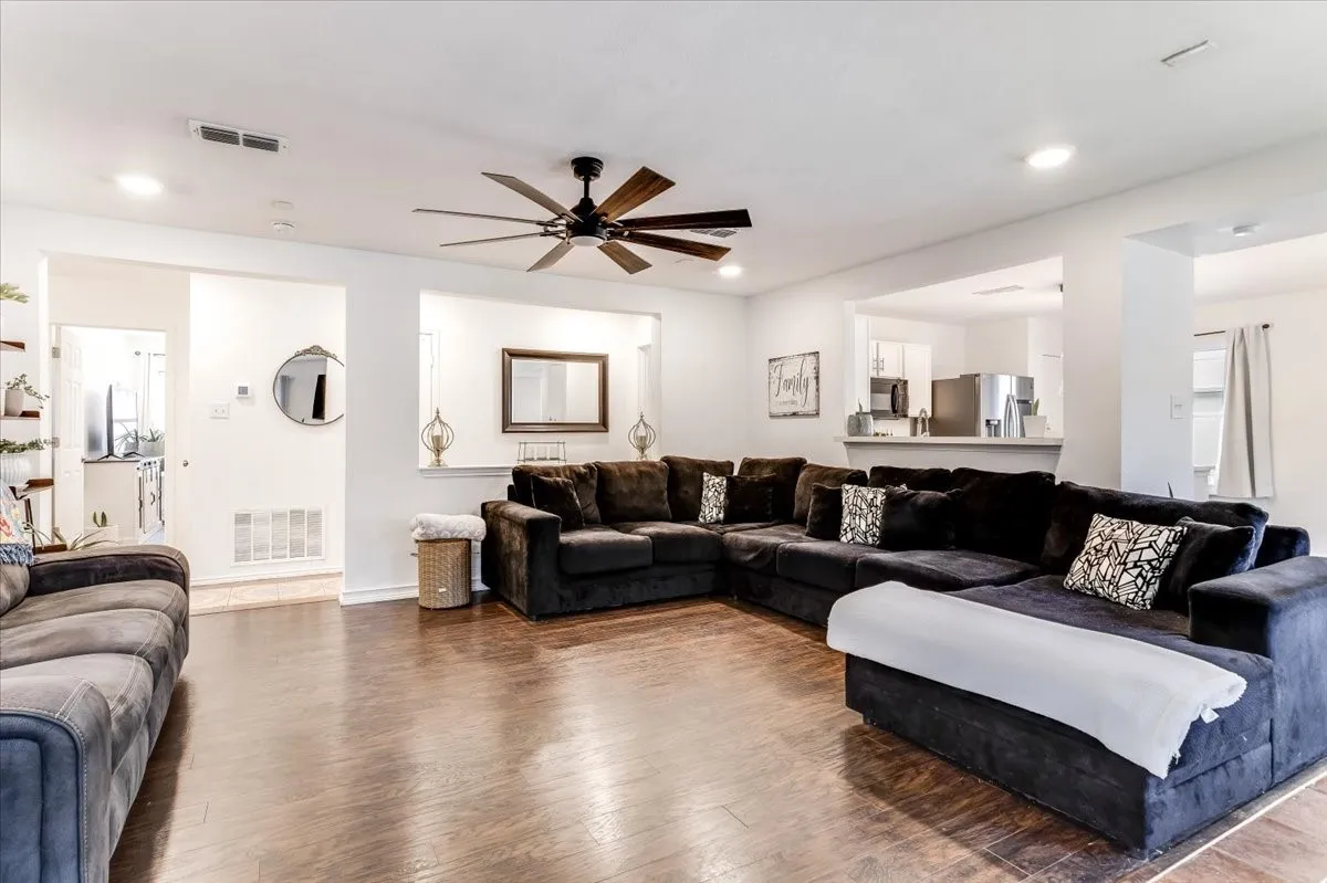 Spacious living area featuring wood-finish flooring, recessed lighting, and a ceiling fan