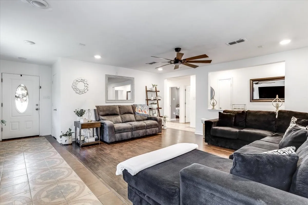 Spacious living area featuring wood-finish flooring, recessed lighting, and a ceiling fan
