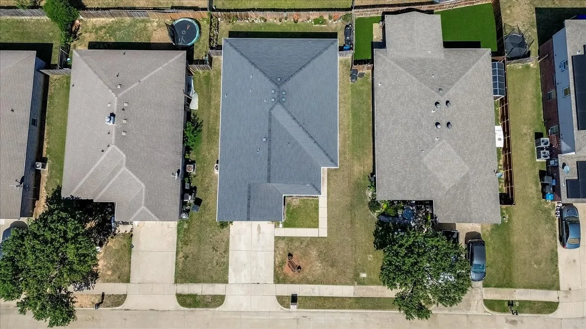 Aerial perspective showcasing a residential property with a dark shingle roof