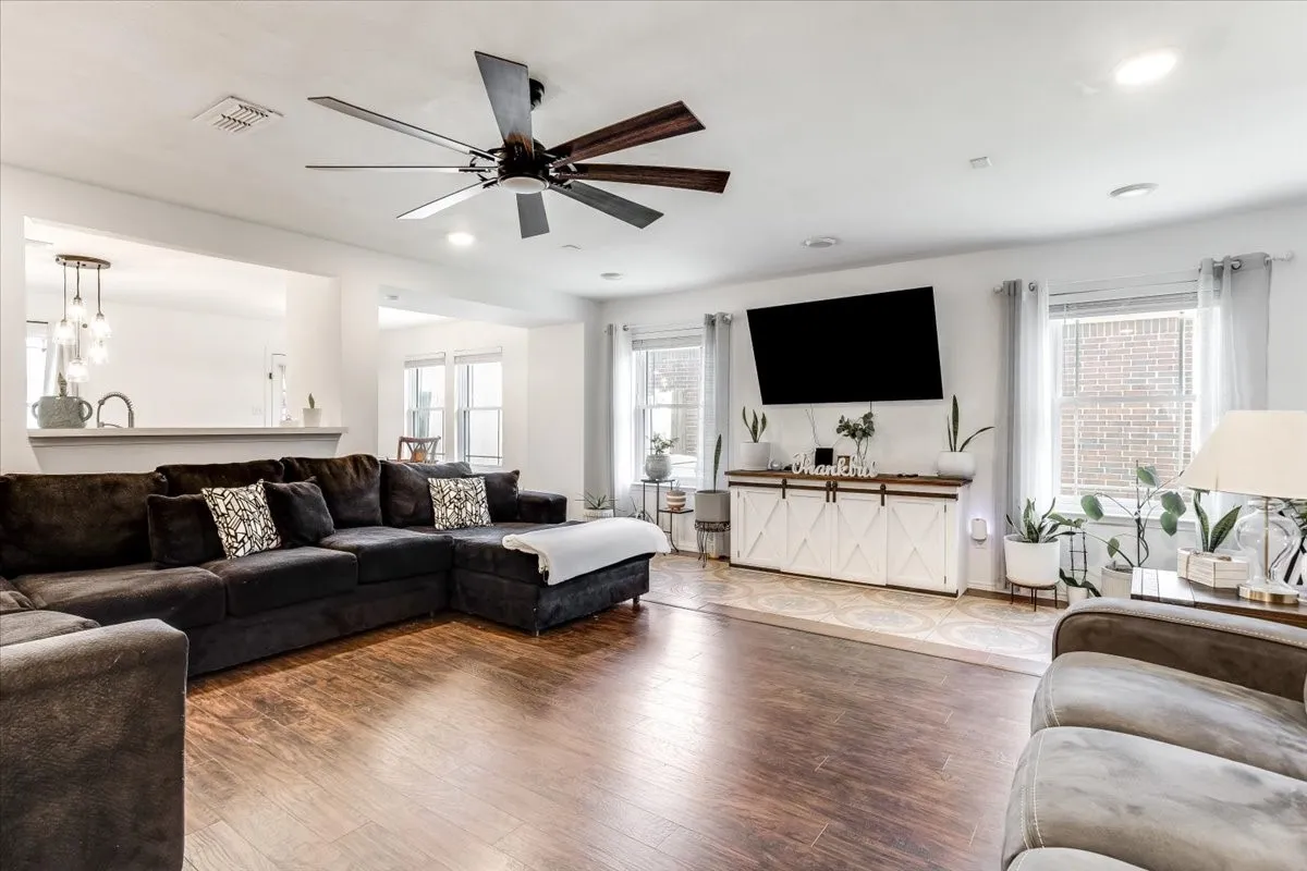 Spacious living area featuring wood-finish flooring, recessed lighting, and a contemporary ceiling fan