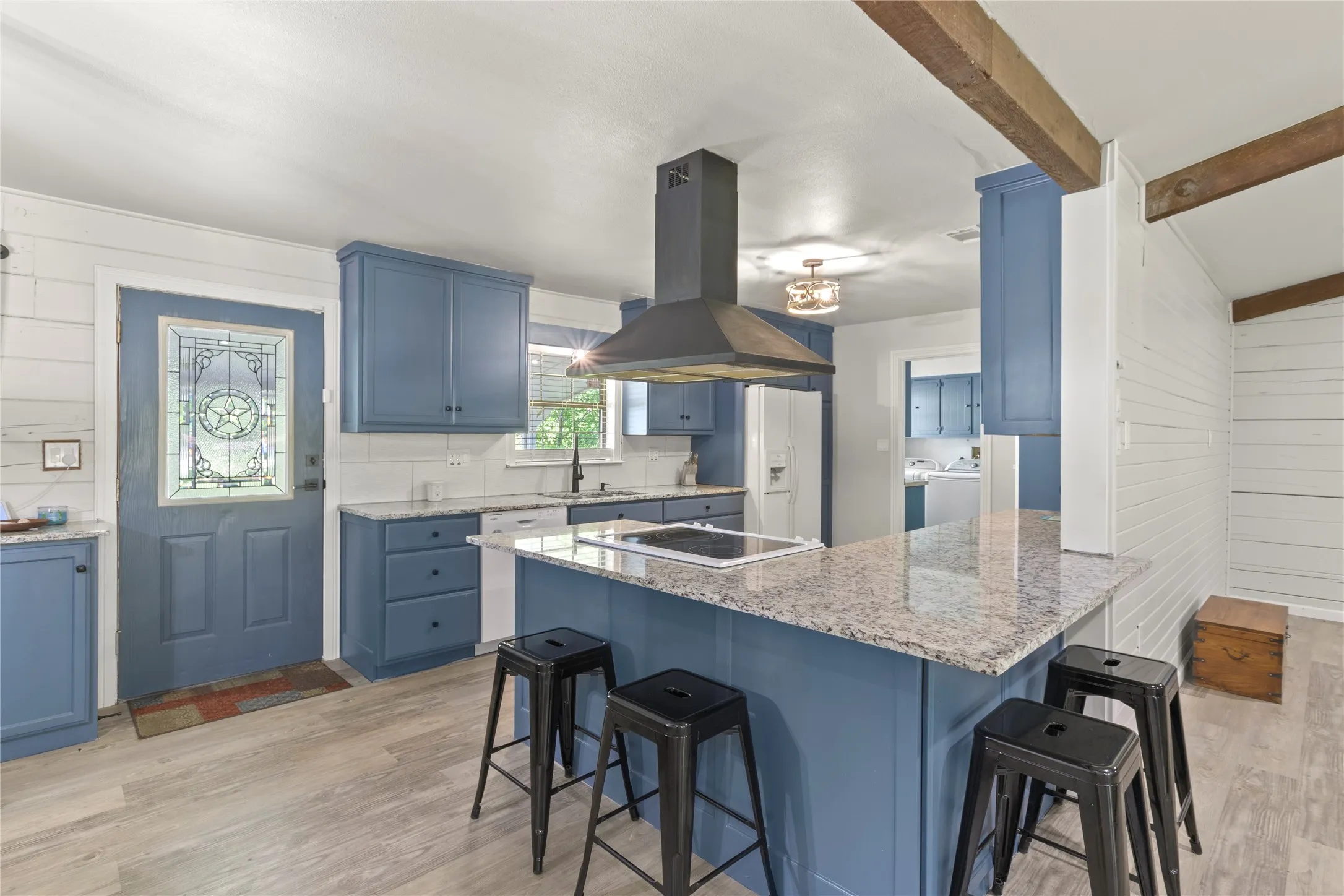Kitchen featuring blue cabinetry, light granite countertops, and a built-in electric cooktop with a range hood