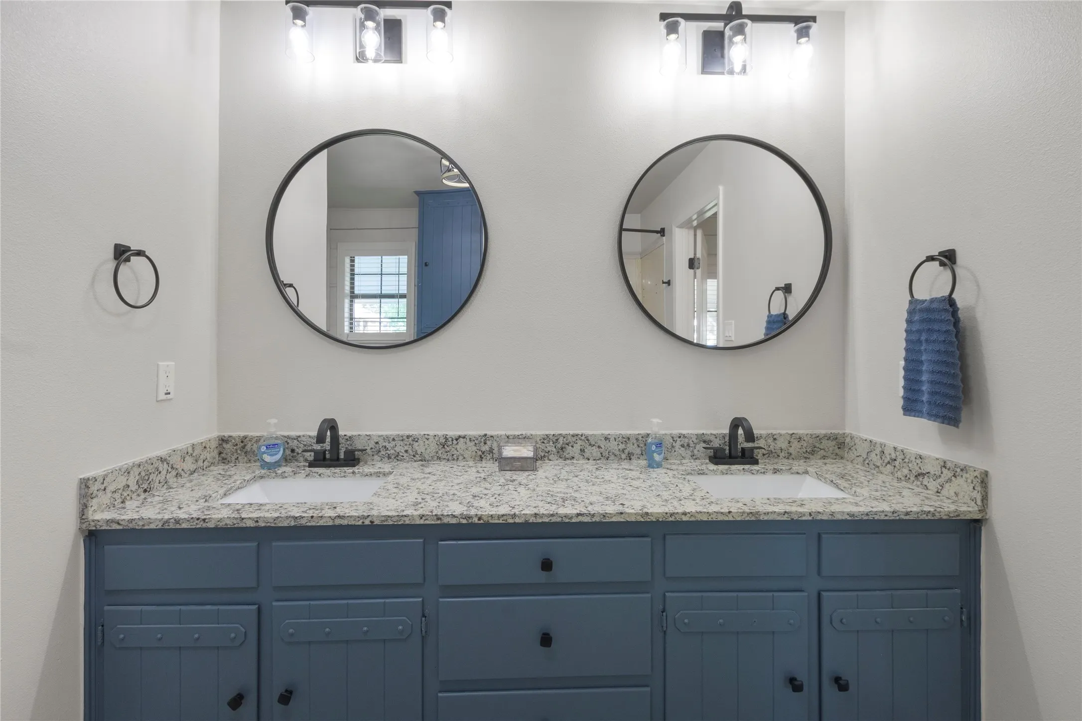 Double vanity with a granite-look countertop, integrated sinks, and matte black fixtures
