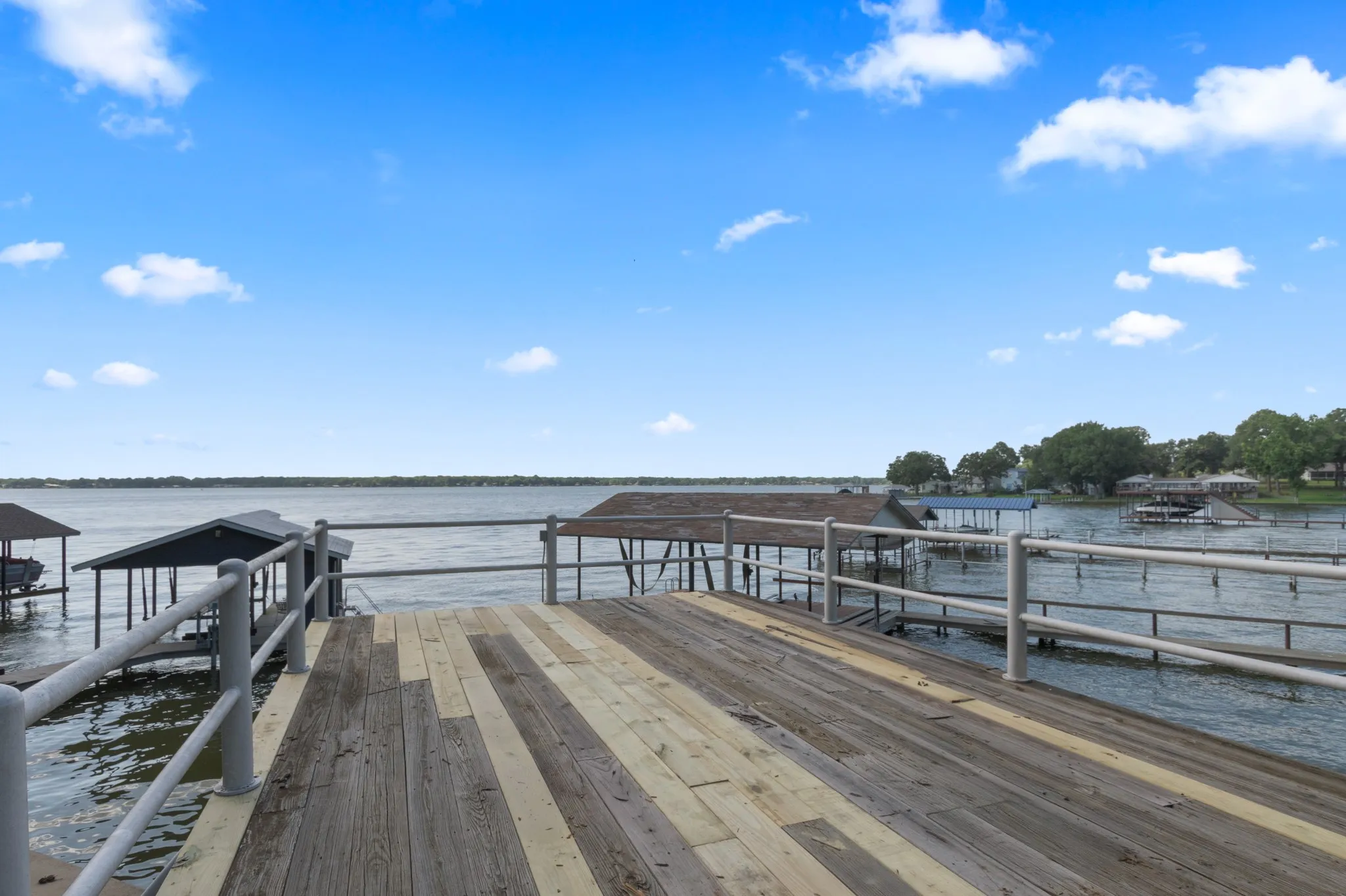 Private boat dock with wood-finish decking and metal railings