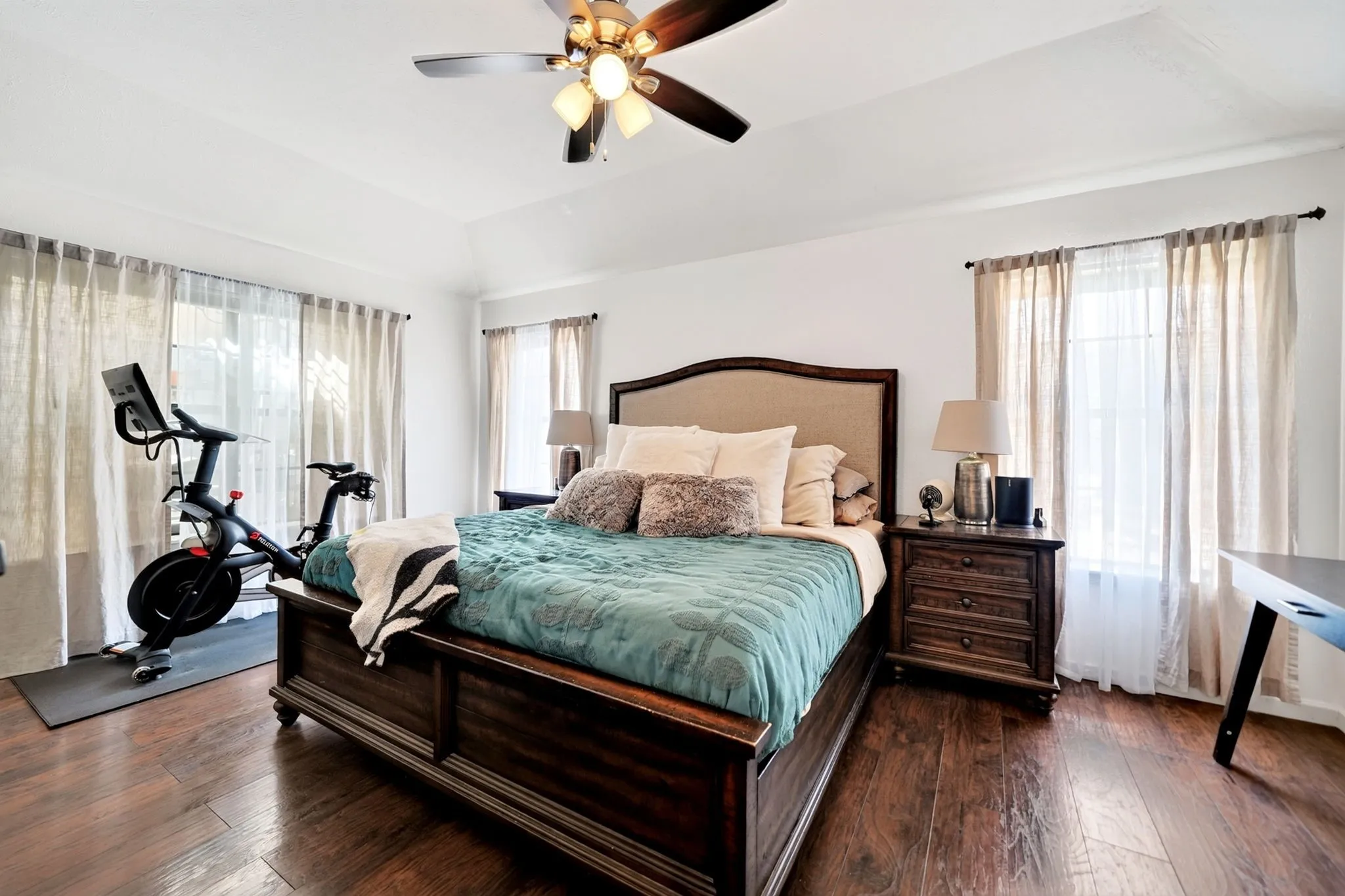 Spacious primary bedroom showcasing massive windows that look out over the private patio and backyard.