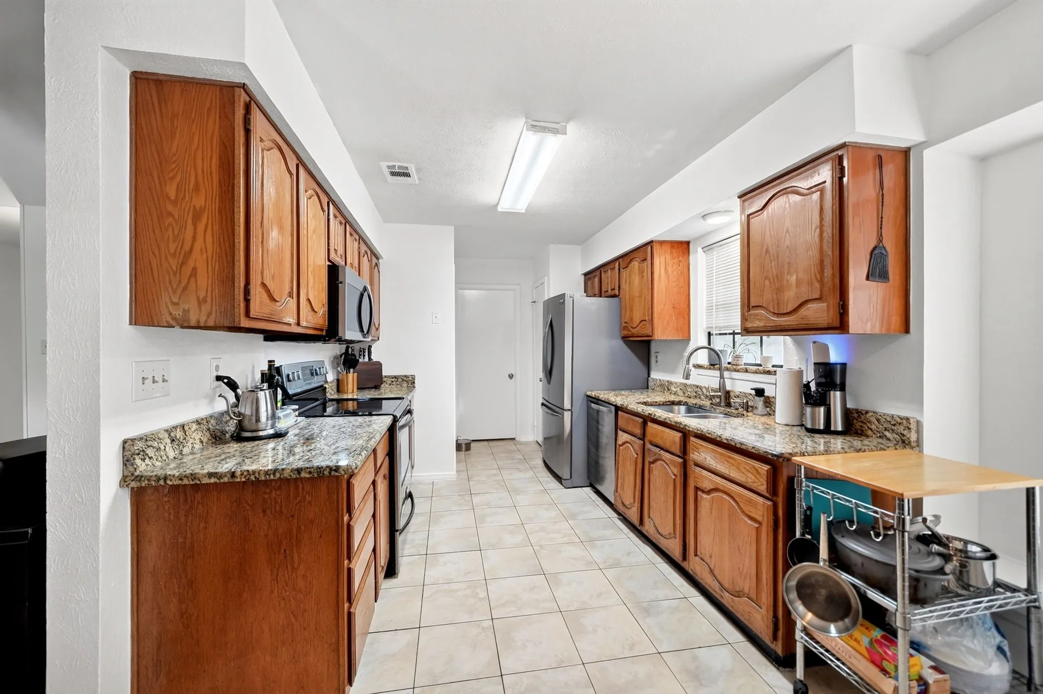 A freshly painted kitchen features a convenient pantry and connects directly to the laundry room.