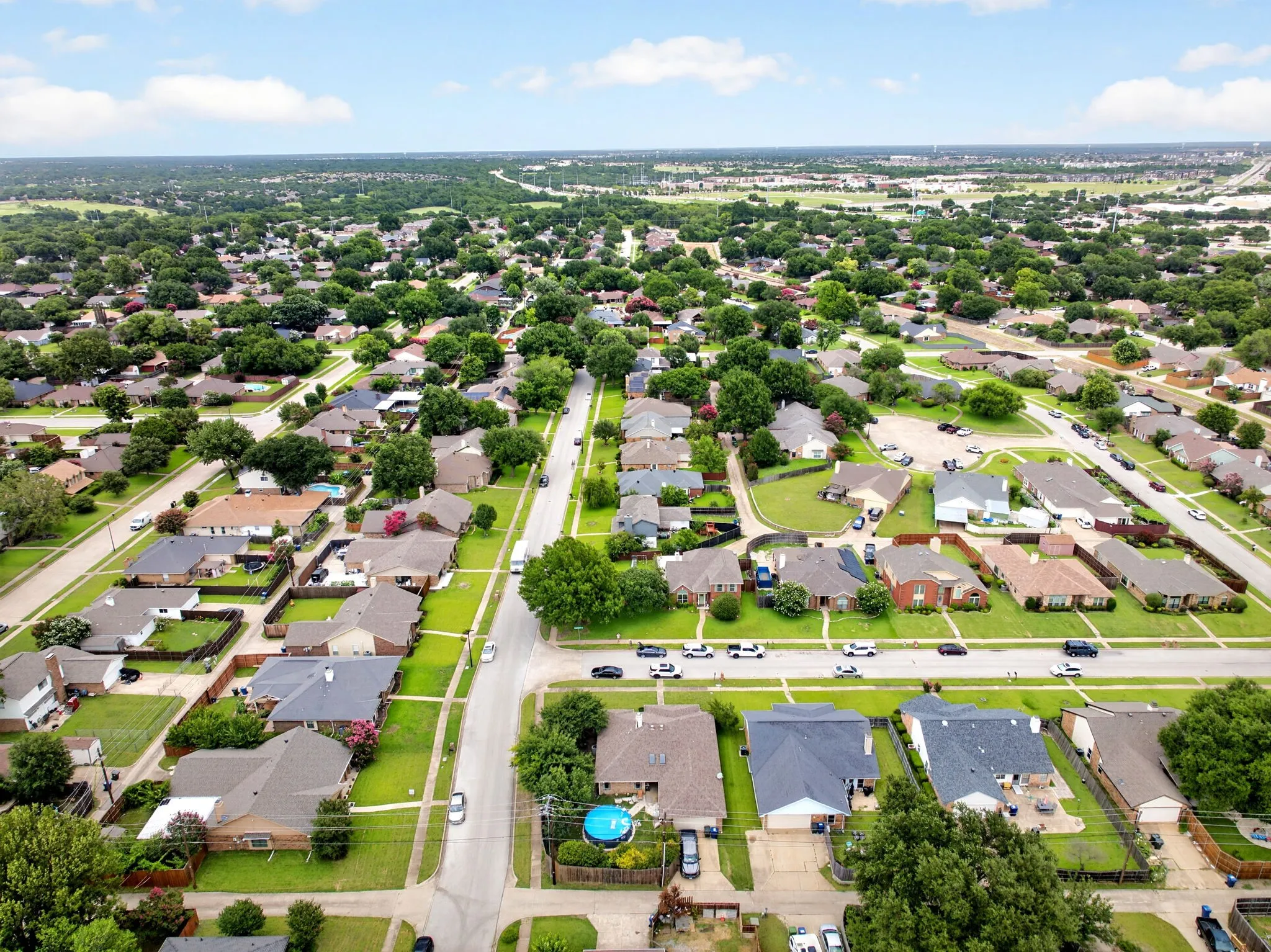 Aerial view of a clean back alley layout, featuring a two-car garage and dedicated driveway parking. Note to buyer, pool has been removed.