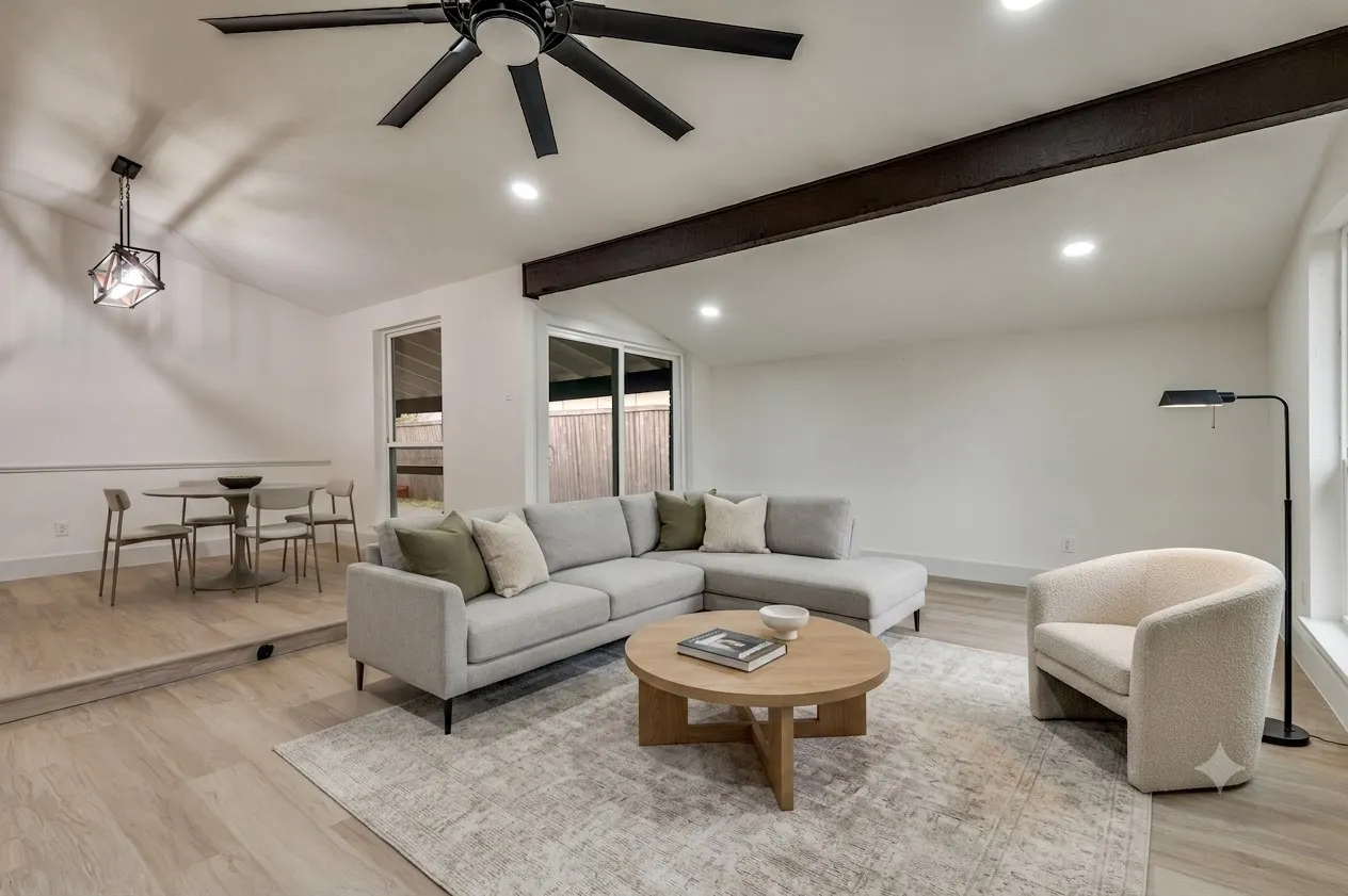 Virutally Staged Vaulted ceiling living area featuring a prominent exposed beam and recessed lighting