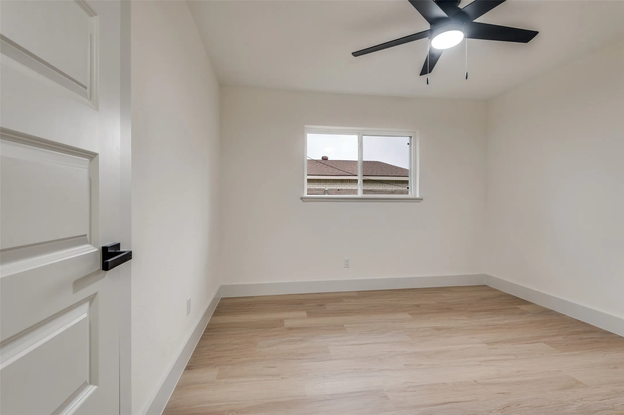 Room featuring light wood-finish flooring and a white color palette
