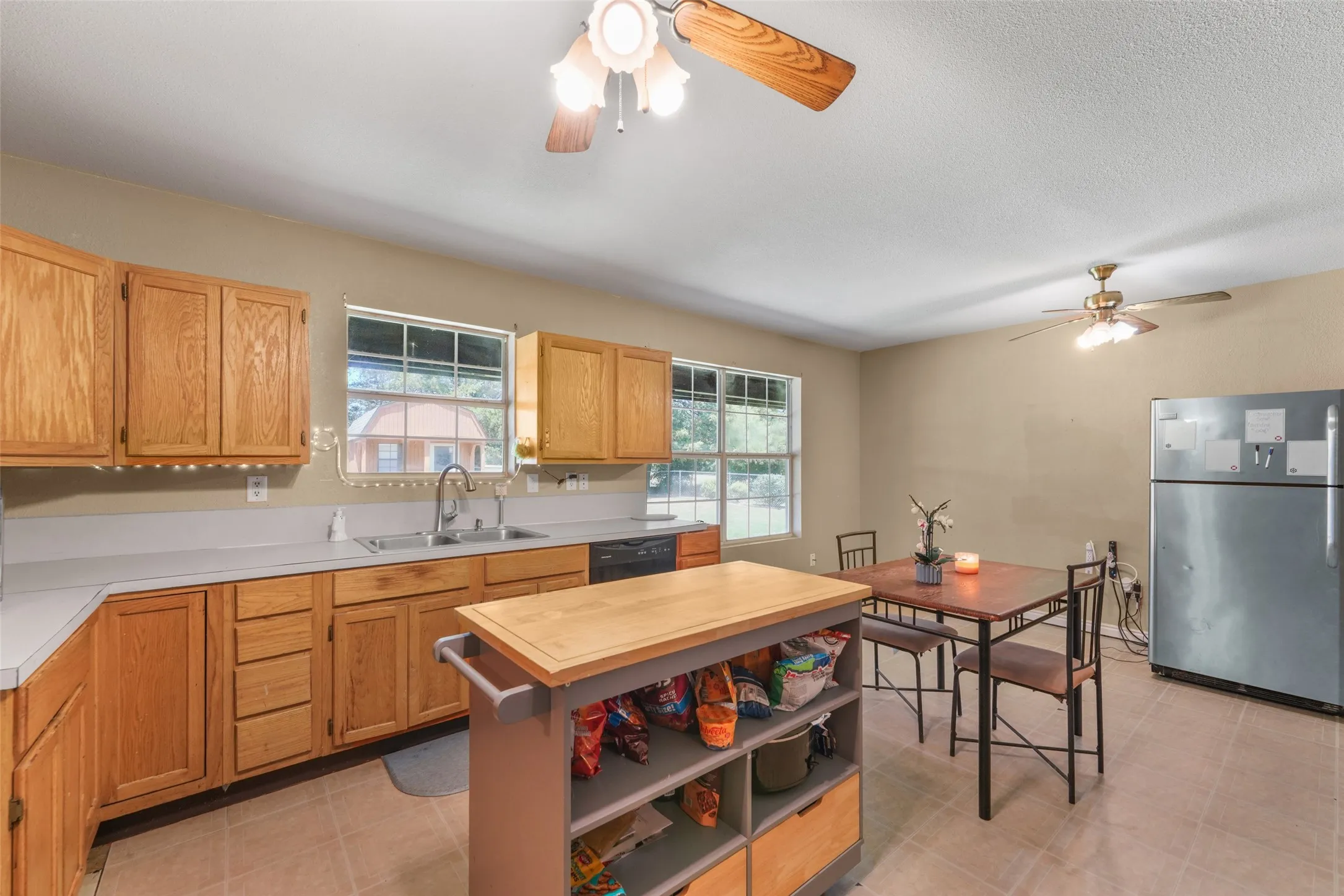 Kitchen featuring wood cabinetry, light countertops, and a stainless steel refrigerator