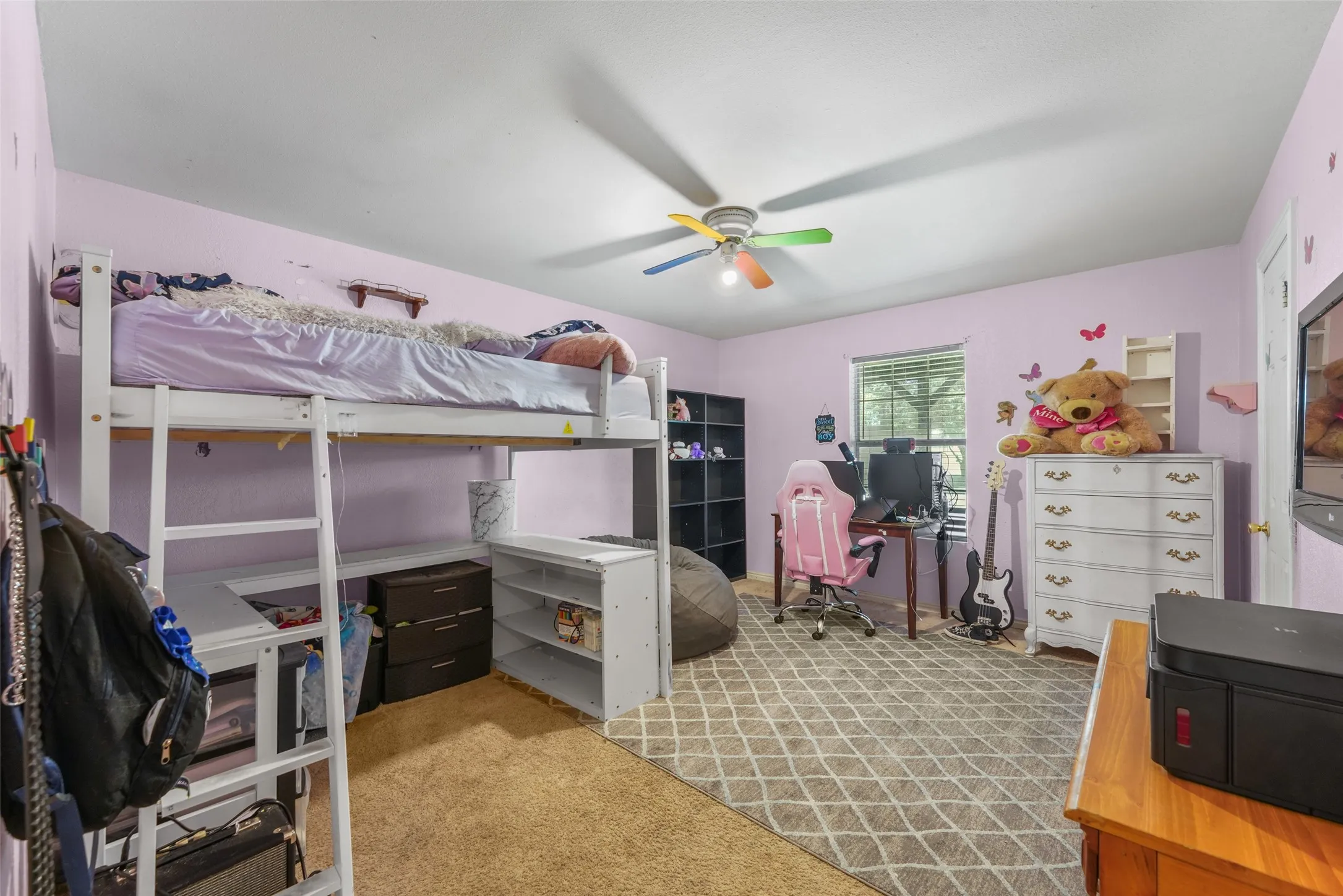 Carpeted room with a ceiling fan, light pink walls, and a visible doorway to an adjacent room