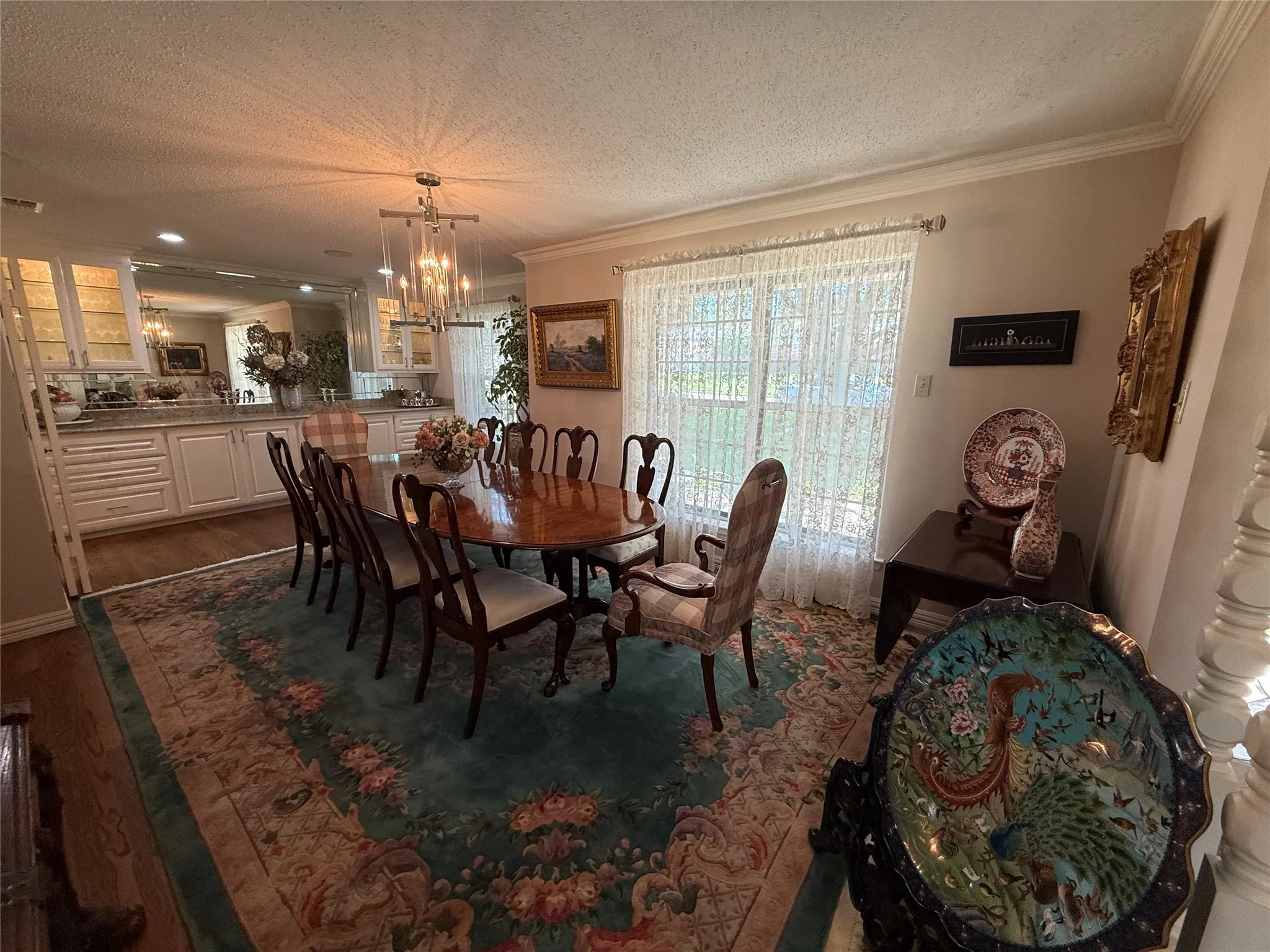 Dining area featuring a wood-finish oval table and a contemporary chandelier