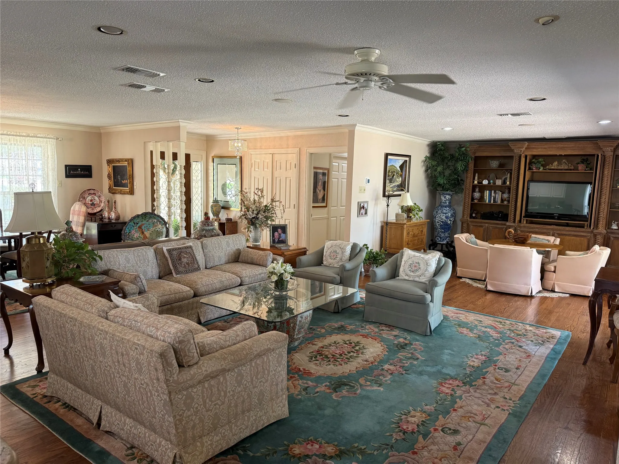 Spacious living area featuring wood-finish flooring, recessed lighting, and a ceiling fan