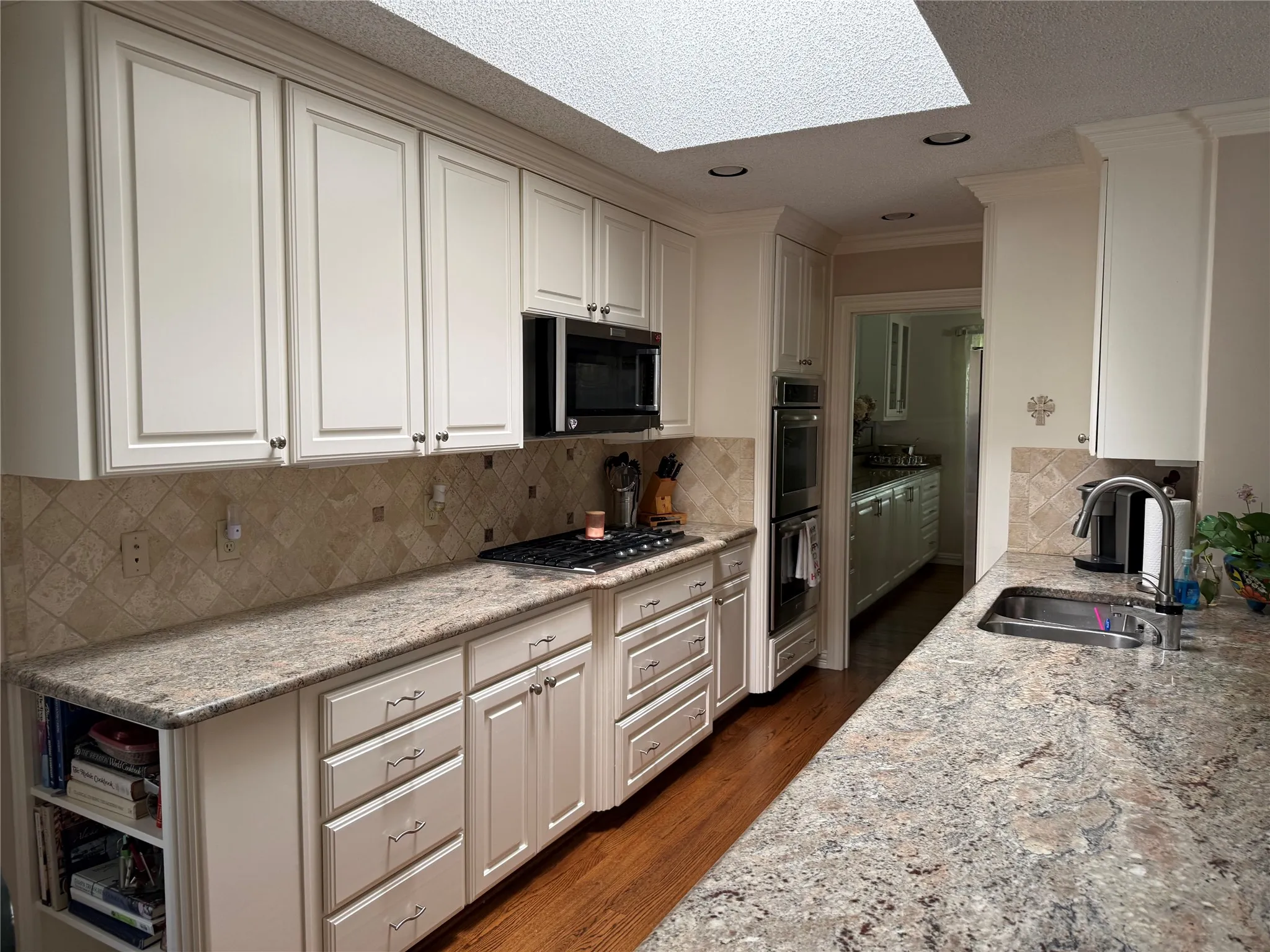 Kitchen featuring cream cabinetry, granite-style countertops, and a full tile backsplash