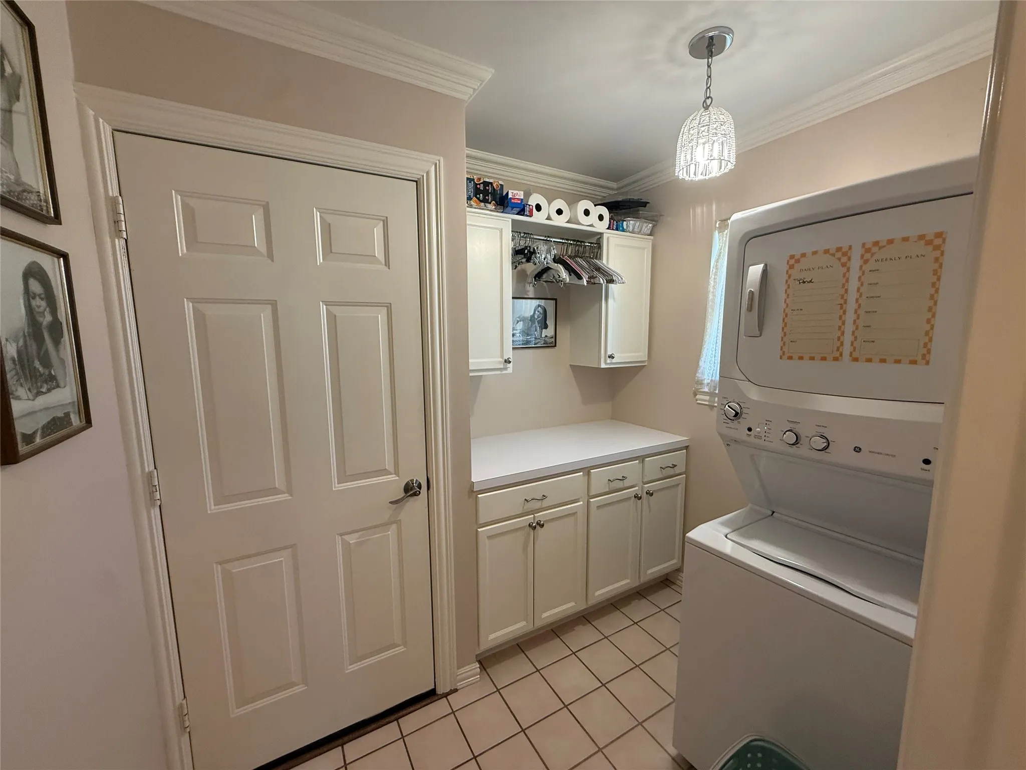 Dedicated utility space featuring a stacked washer and dryer unit