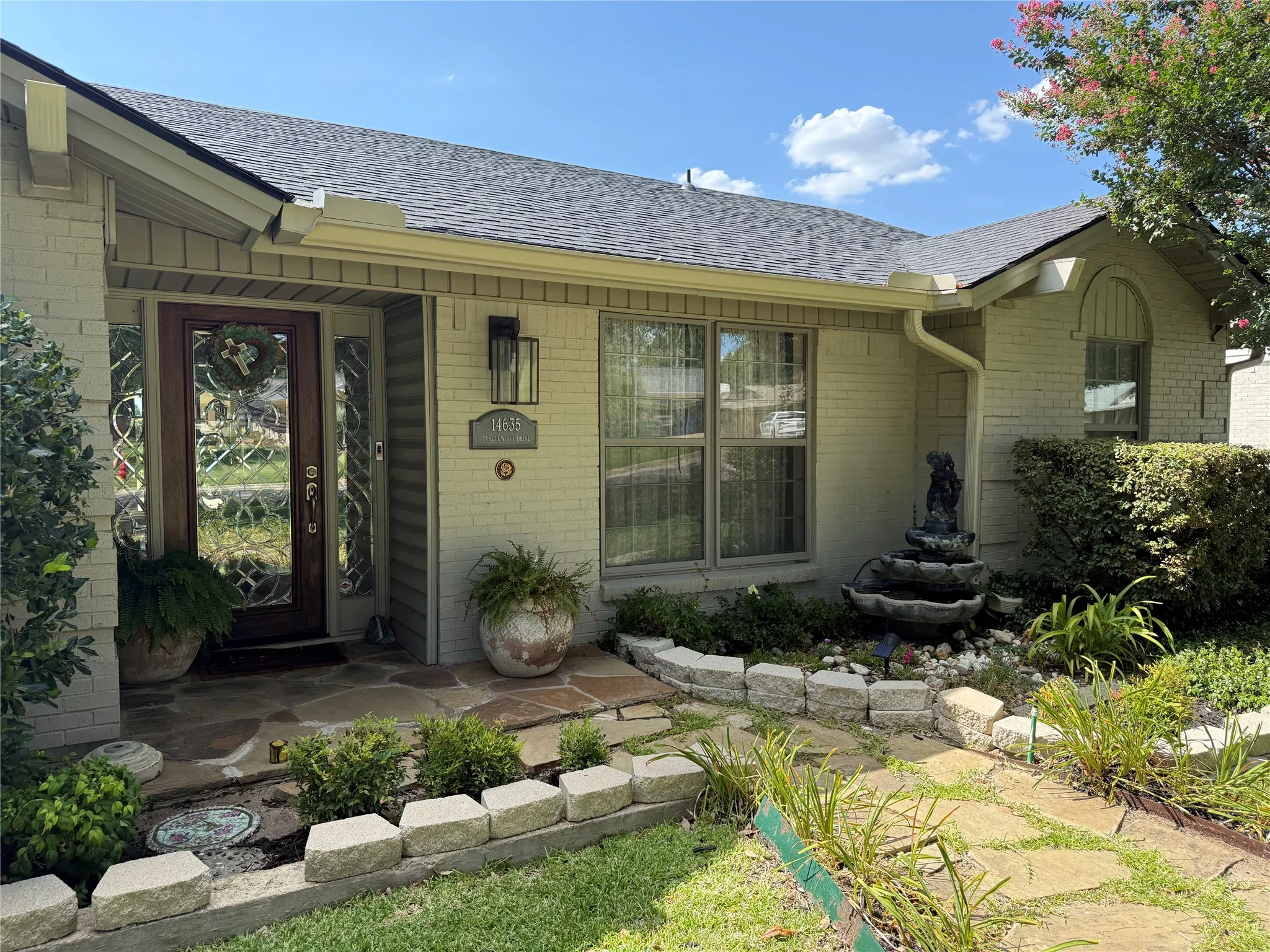 Light brick exterior with a dark shingle roof