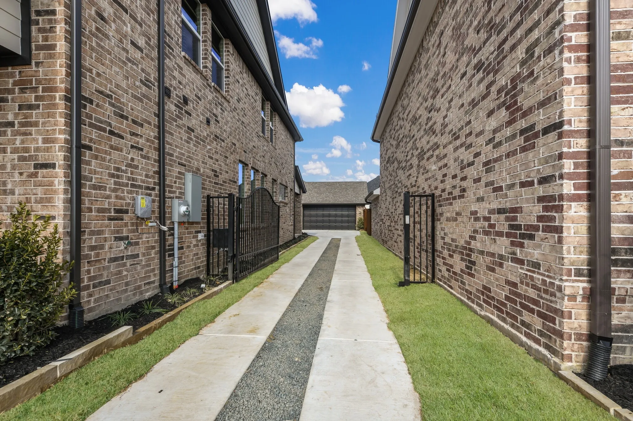 With striking brick and dark trim, a private, gated drive and rear garage, this charming dream home has outstanding curb appeal!