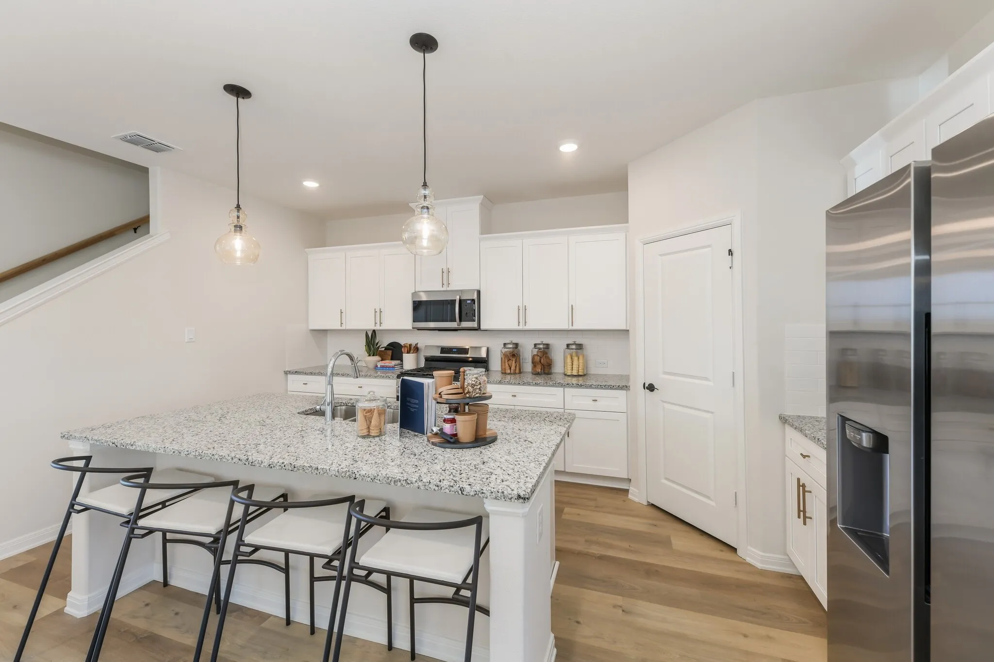 A beautiful crisp clean white color palette and modern flooring effortlessly pair with contemporary stainless steel to create a kitchen for the ages!