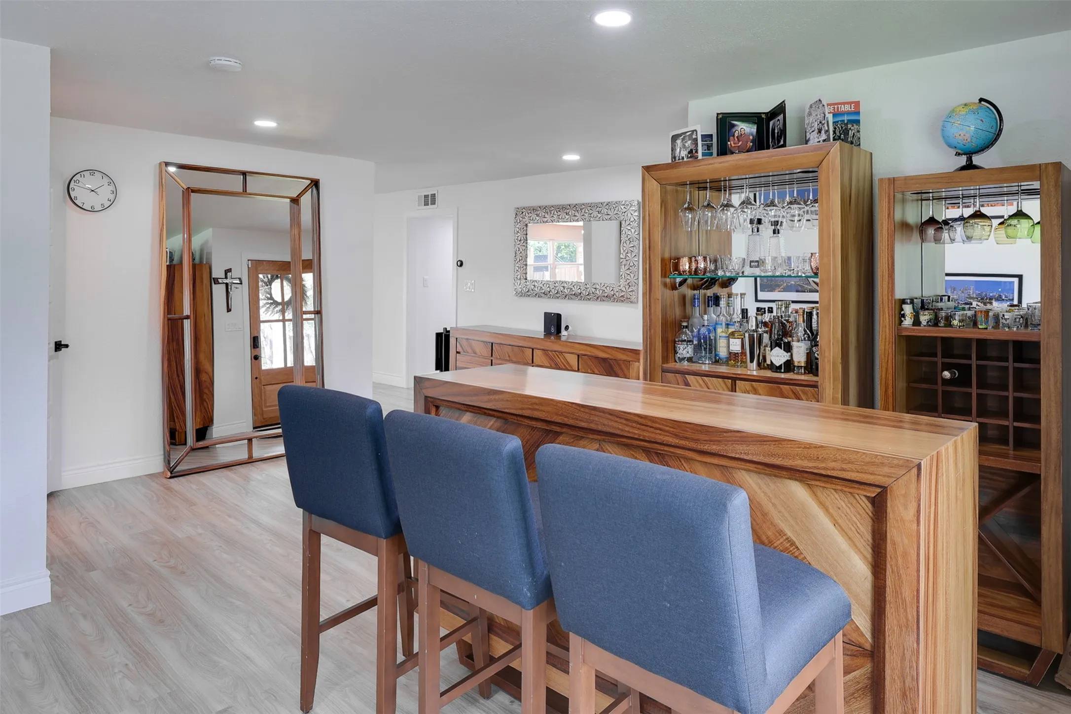 Custom built-in bar featuring rich wood cabinetry, integrated wine storage, and stemware racks