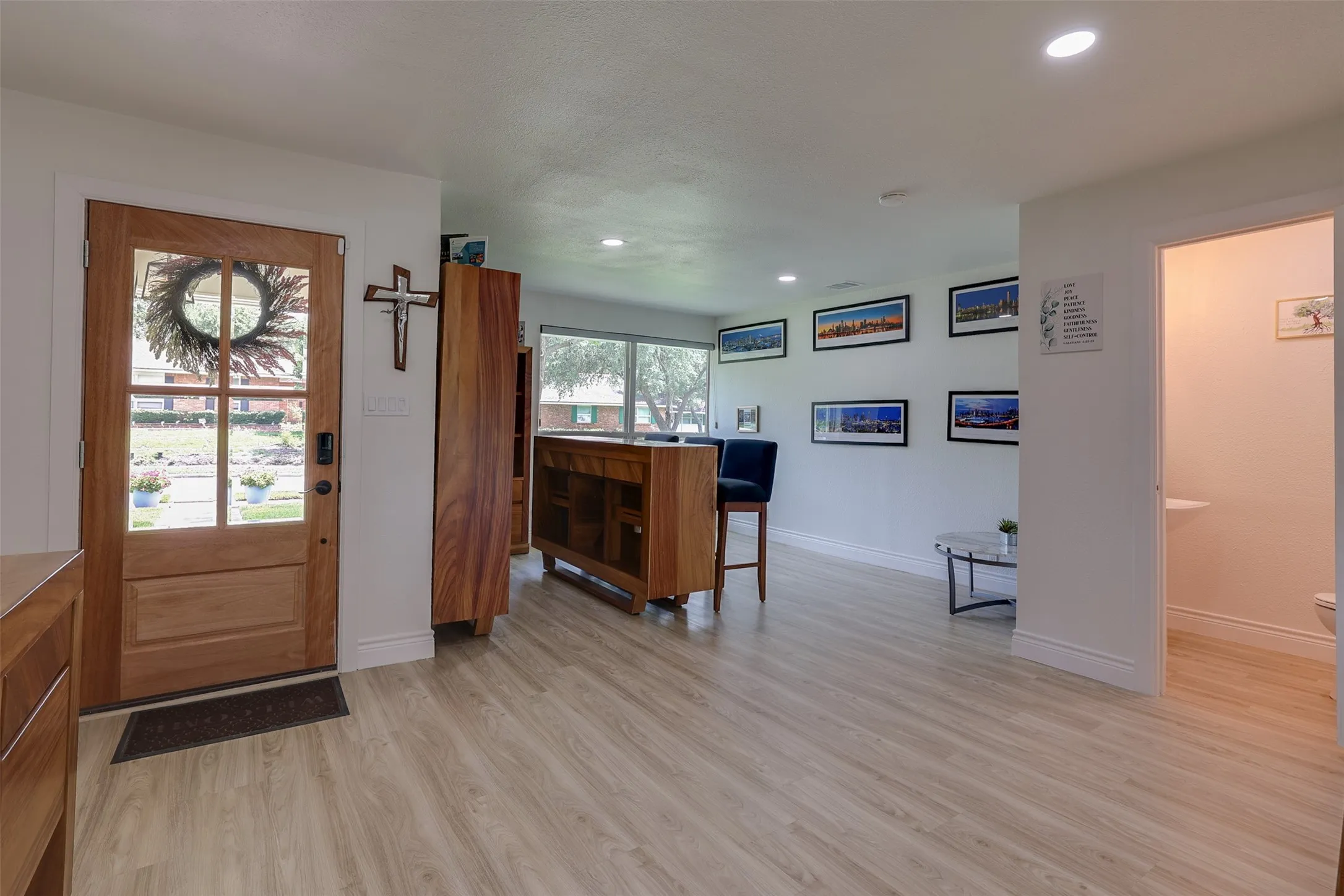 Entryway featuring a wood-panel door with glass inserts, wood-finish flooring, and recessed ceiling lighting