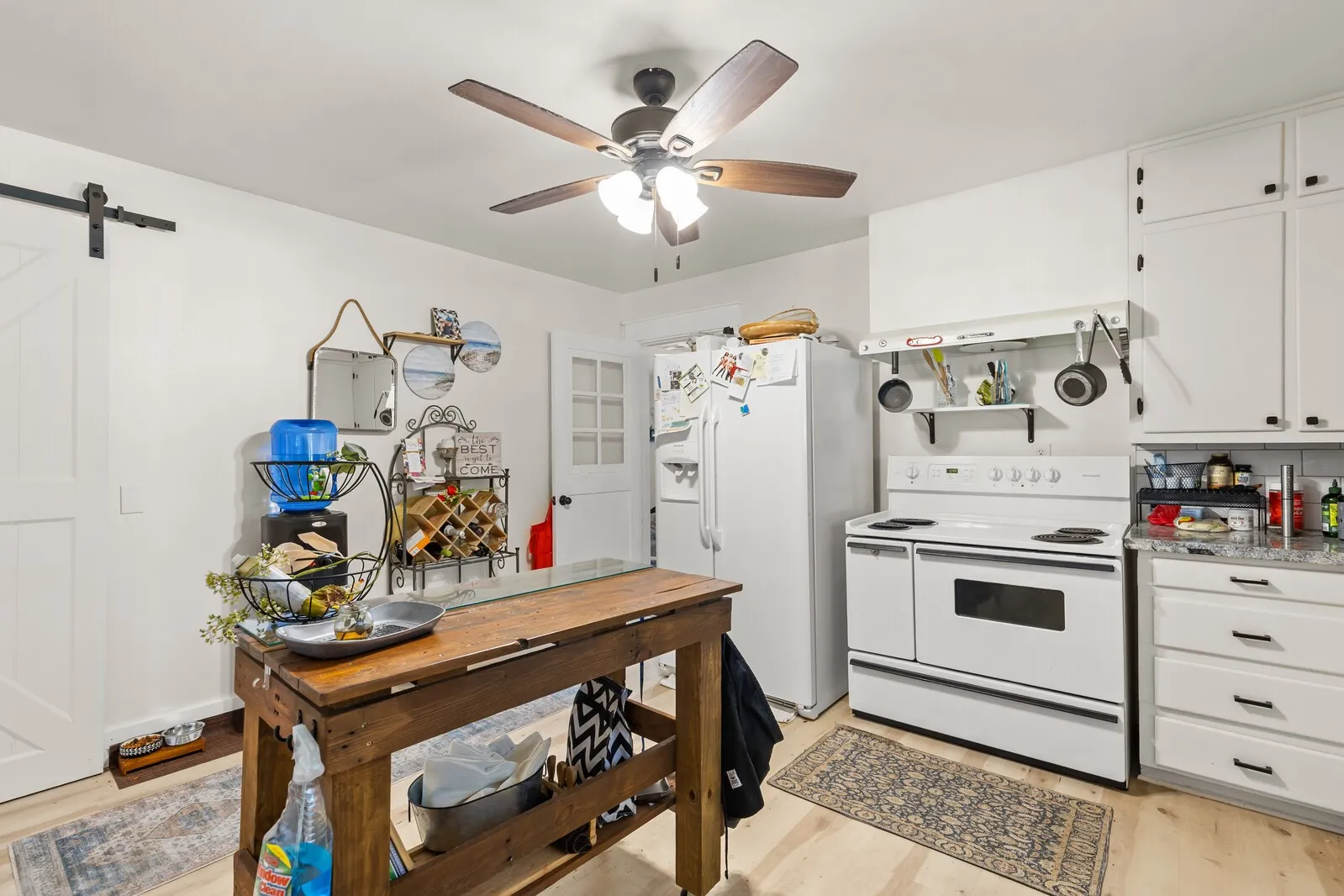 Efficient kitchen featuring white cabinetry, a white electric range, and wood-finish flooring
