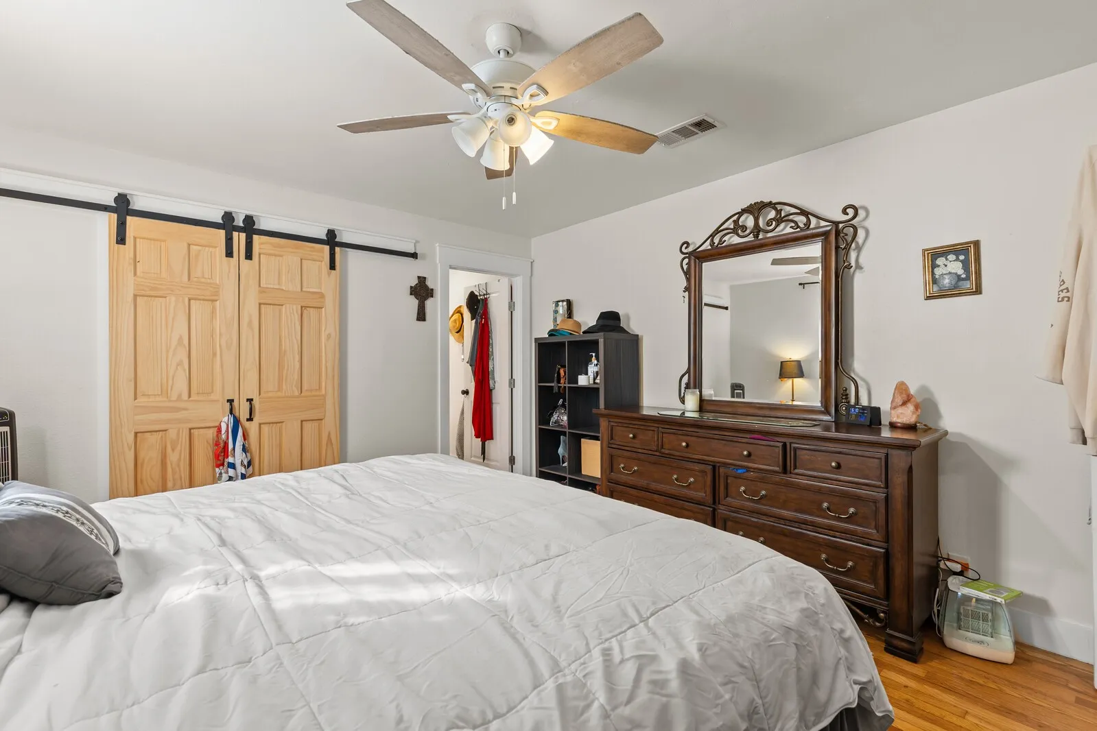 Bedroom featuring wood-finish flooring, a ceiling fan, and white walls