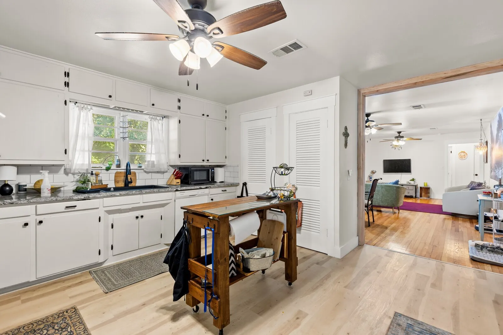 Kitchen featuring abundant white cabinetry, light countertops, and light wood-finish flooring