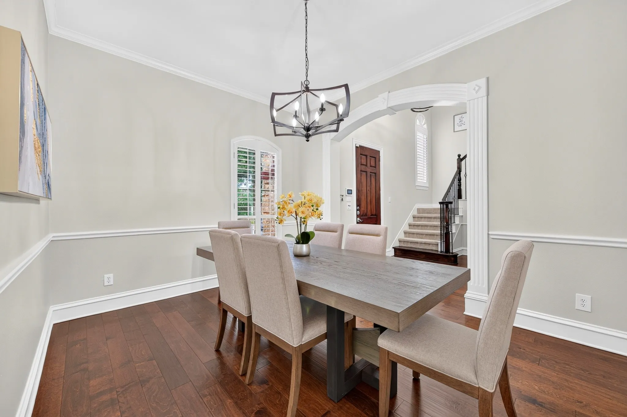 Formal dining space featuring wood-finish flooring, wainscoting, and crown molding