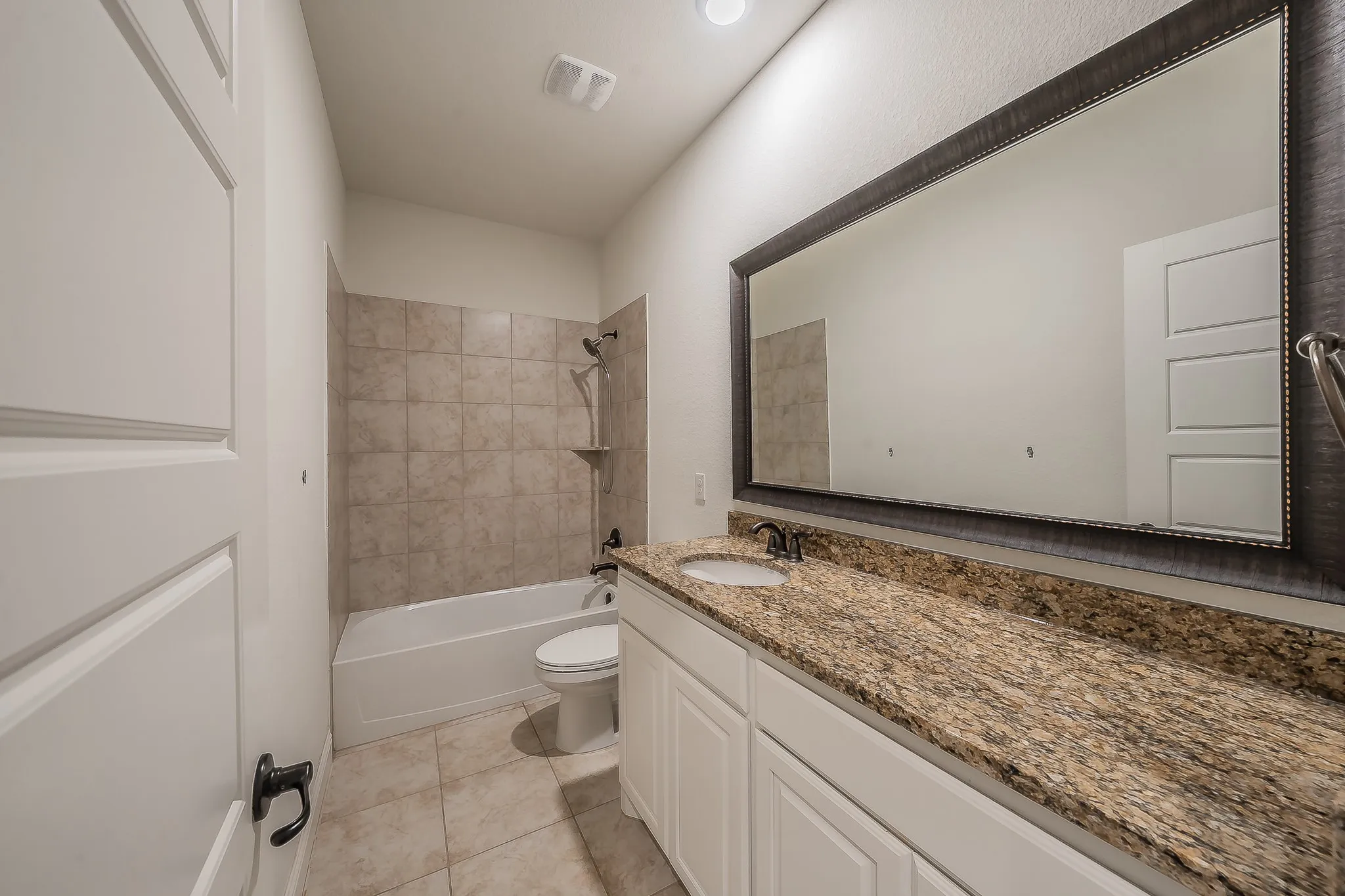 Bathroom featuring a vanity with a light-toned stone countertop and undermount sink