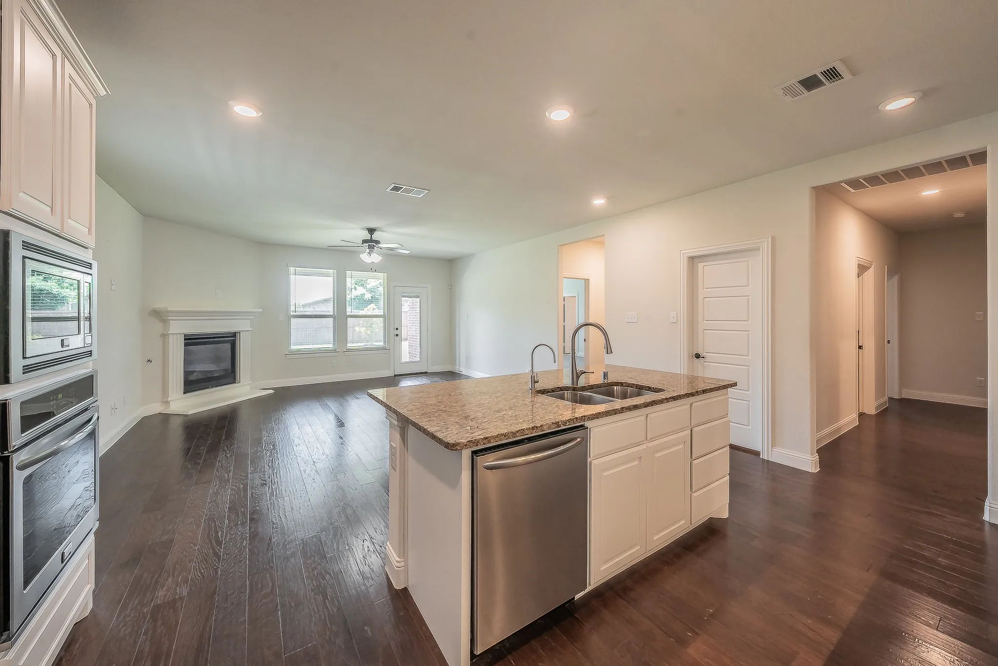 Kitchen island featuring a double basin sink and stainless steel dishwasher