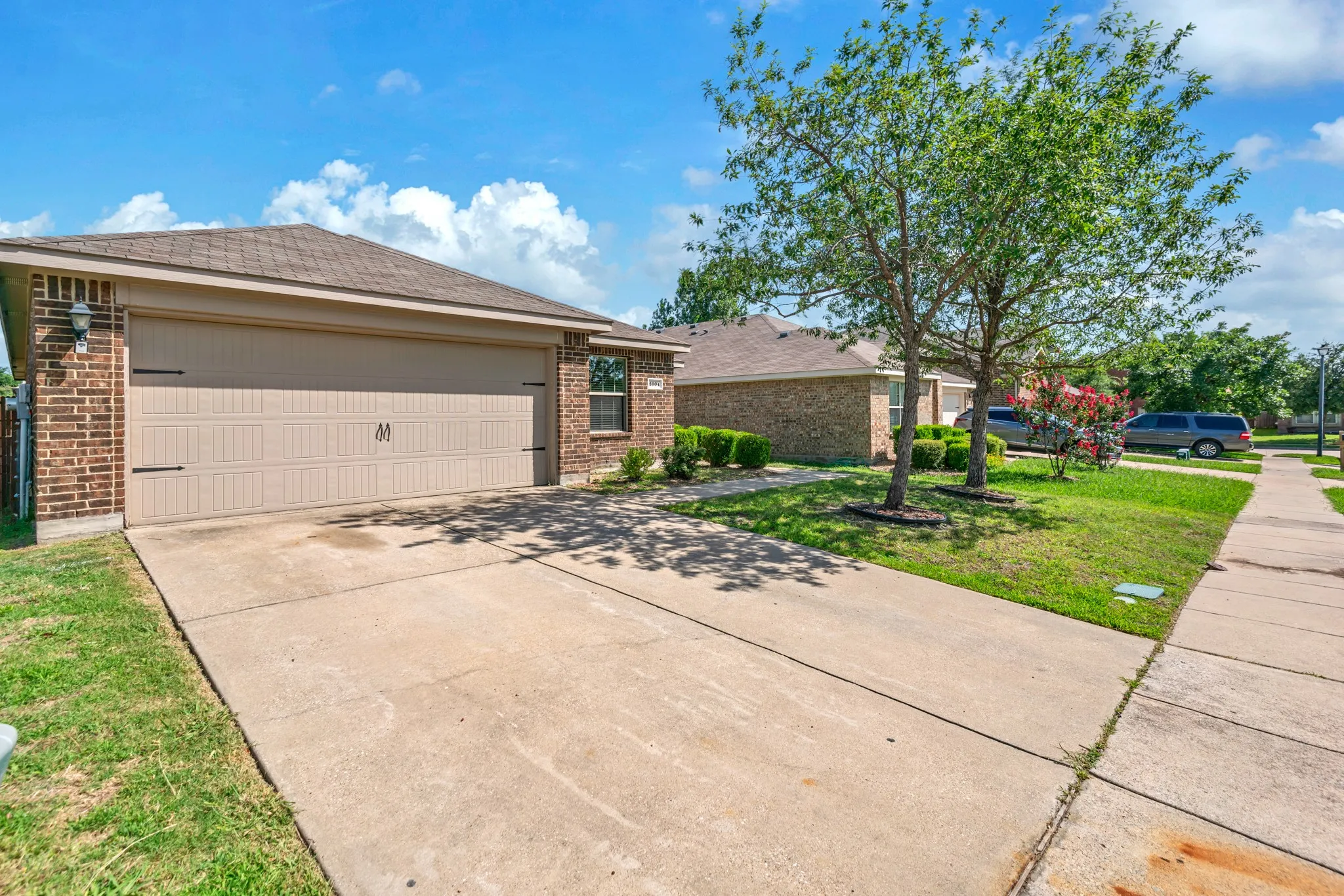 Brick exterior with a two-car garage featuring decorative hardware