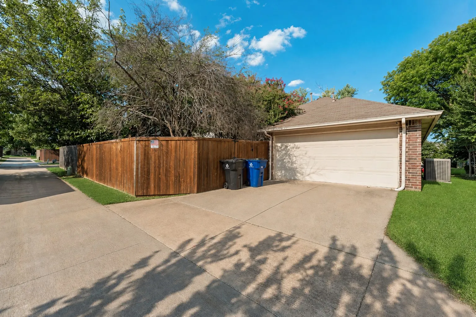 Attached two-car garage with a light-colored door and brick siding