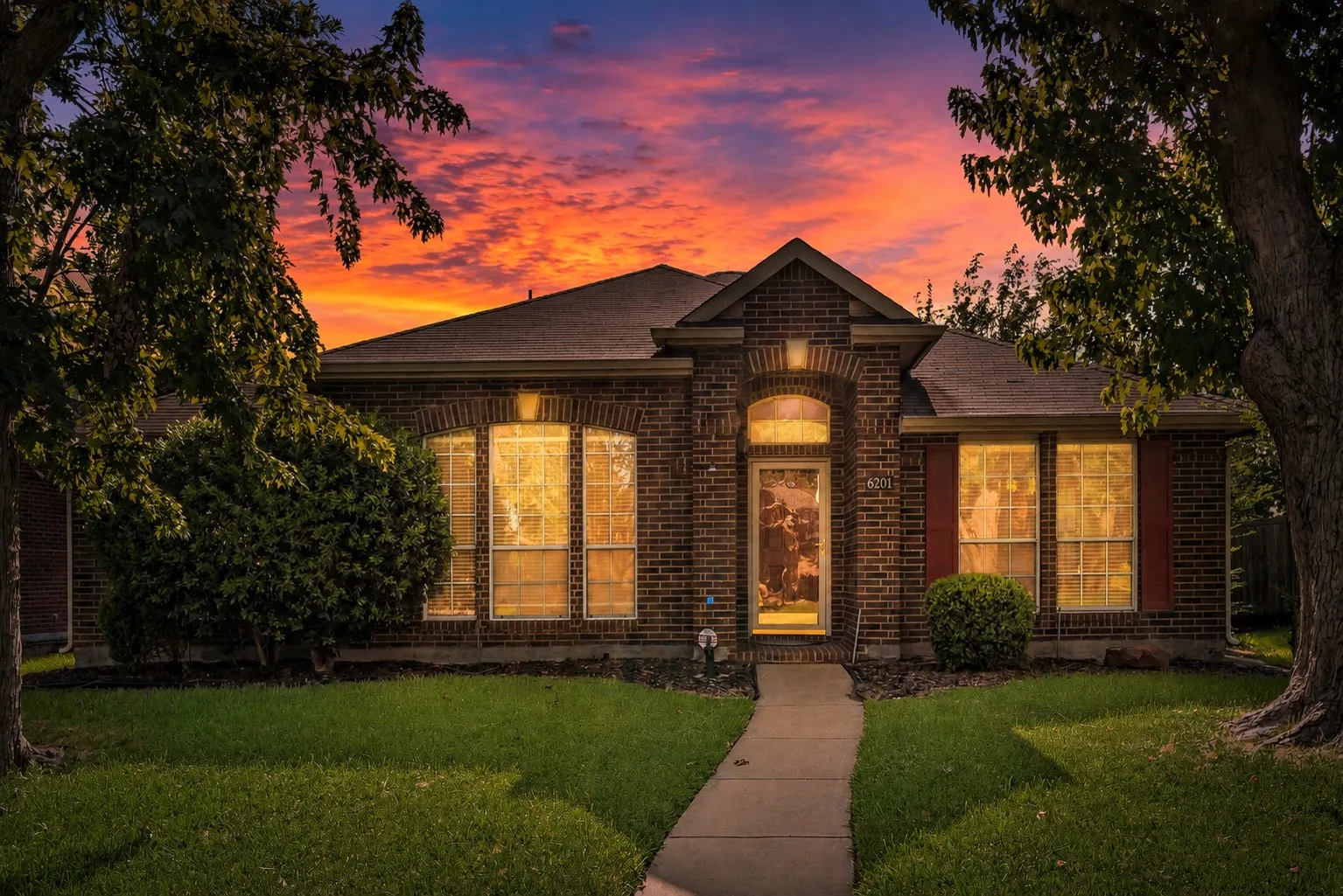 Brick exterior residence featuring a covered entry, arched transom window, and a gabled roofline