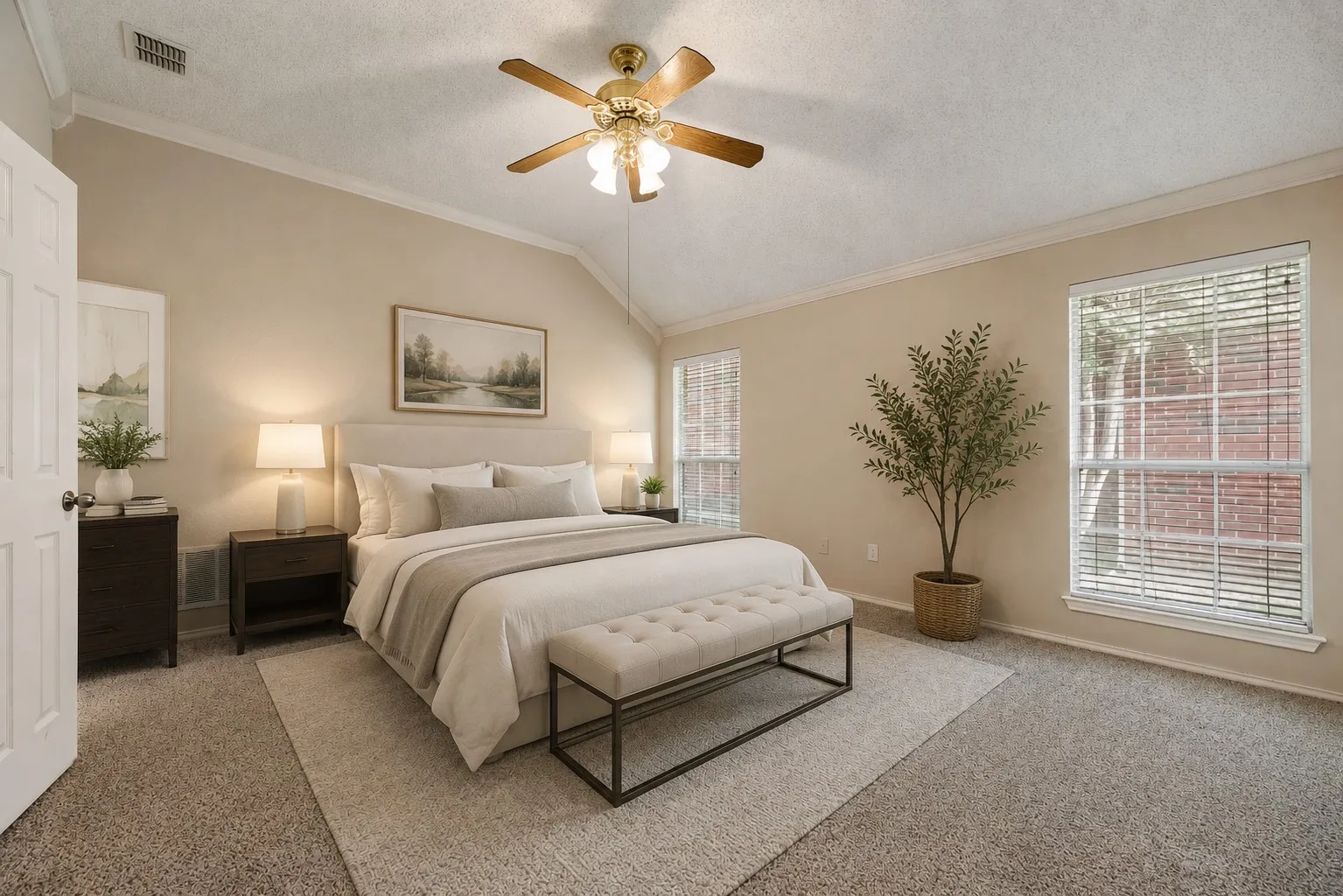 Vaulted ceiling bedroom with neutral wall tones and plush carpeting