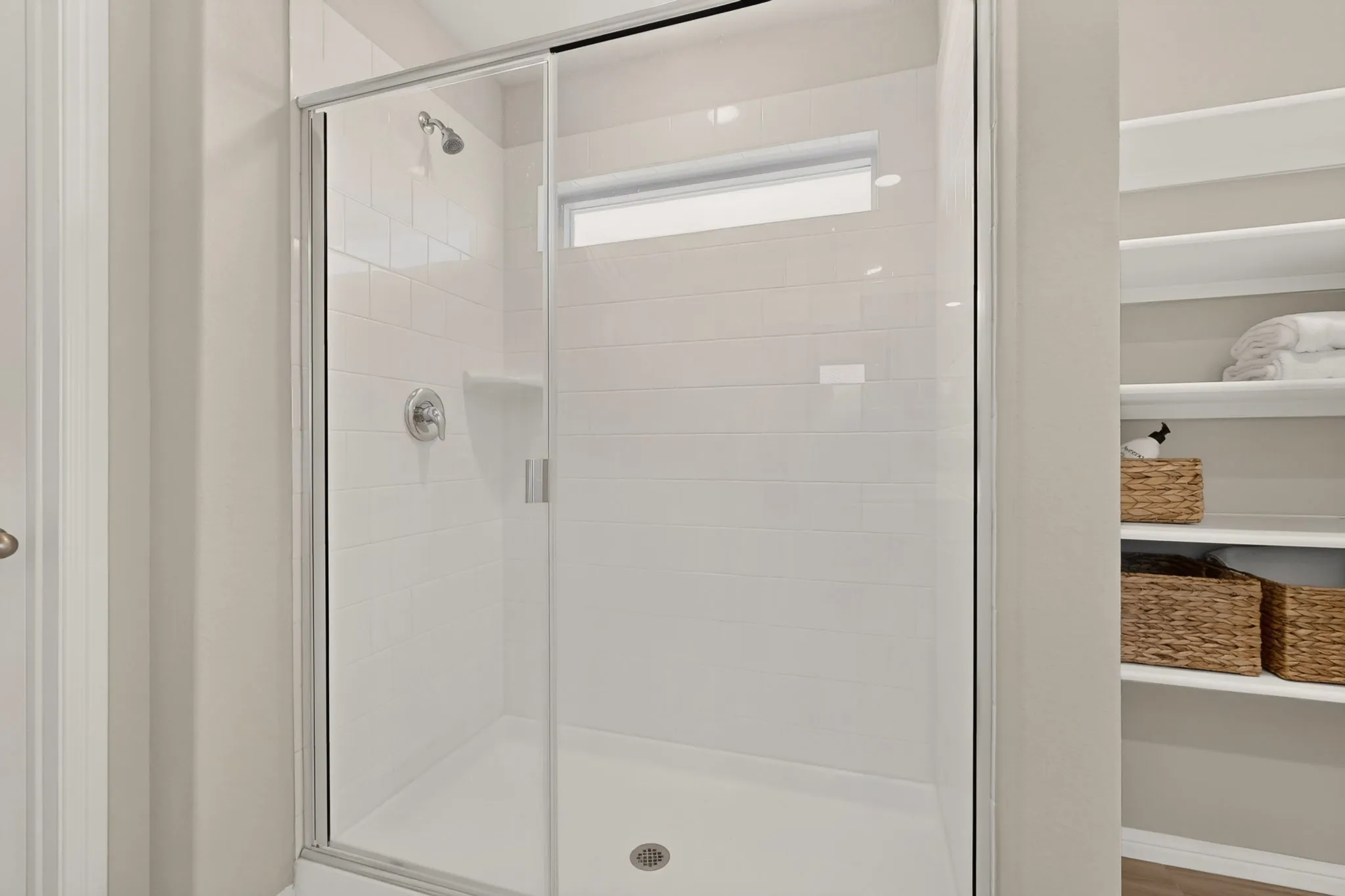 Shower enclosure with clear glass doors and chrome hardware