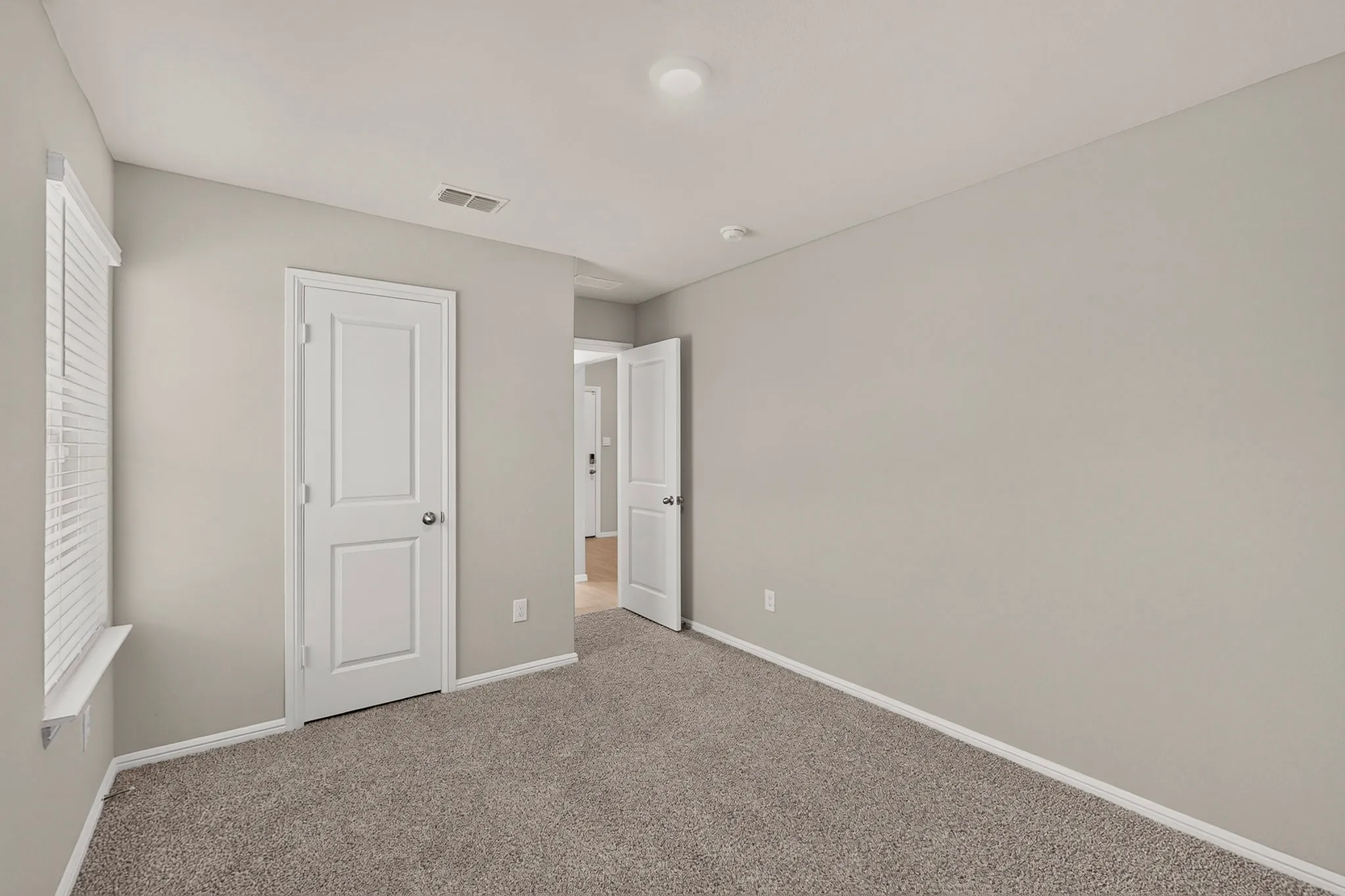 Carpeted interior space with light gray walls and white trim