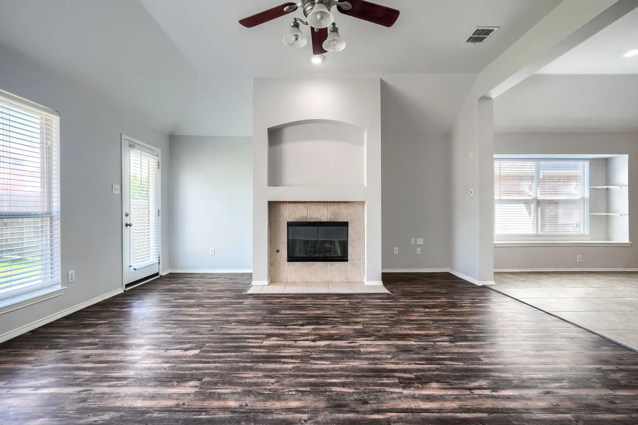 Living area featuring wood-finish flooring and a tiled fireplace surround with an integrated firebox
