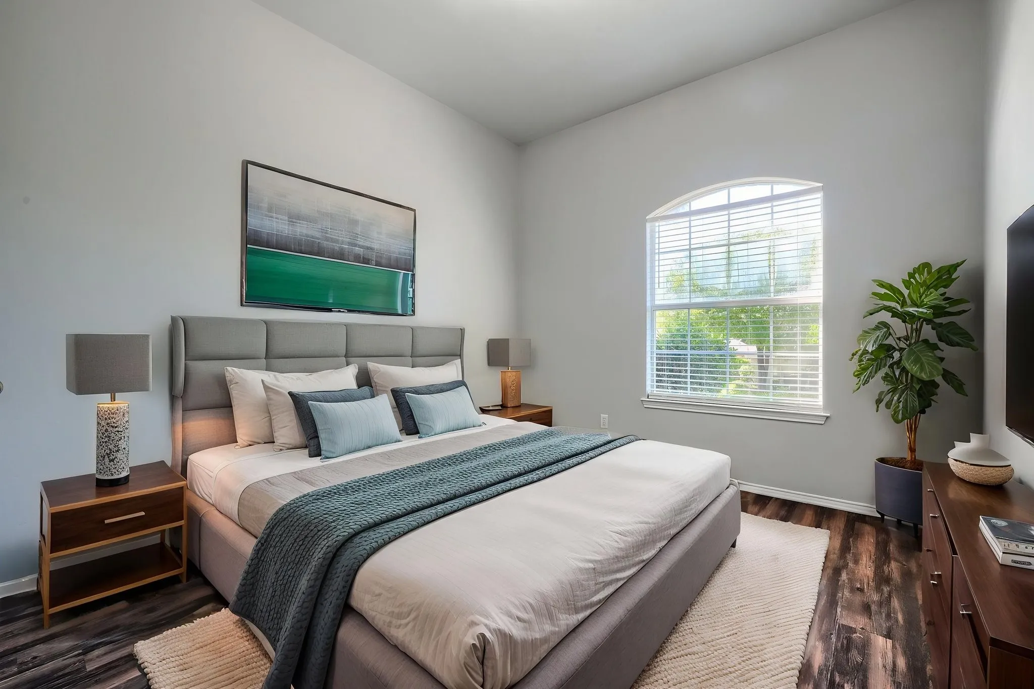 Bedroom featuring a vaulted ceiling and an arched window with blinds