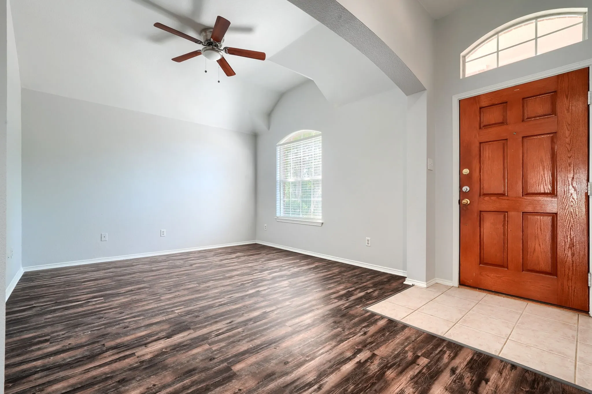 Entry foyer featuring a paneled wood door with an arched transom window