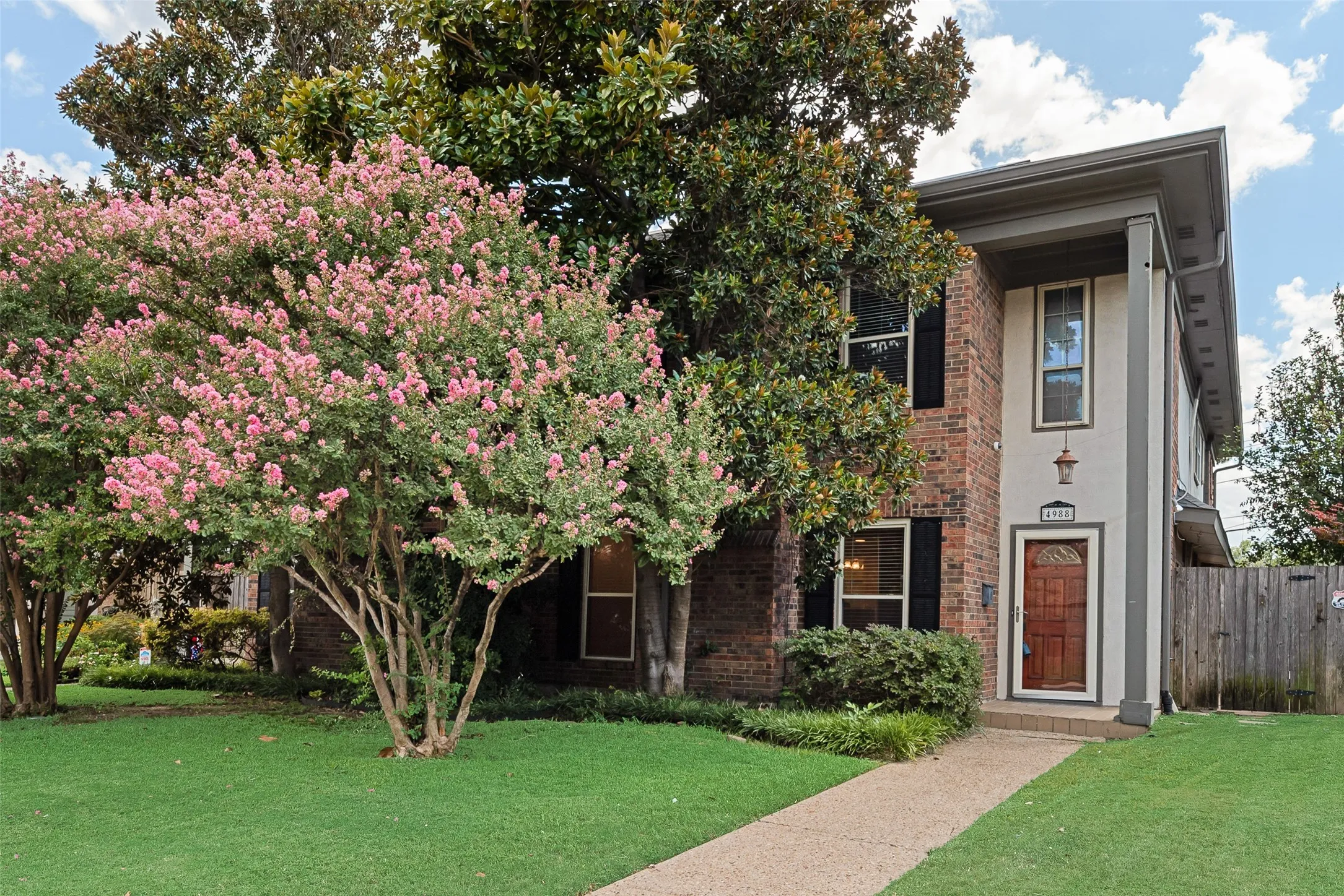 Brick exterior with contrasting stucco elements and dark window shutters