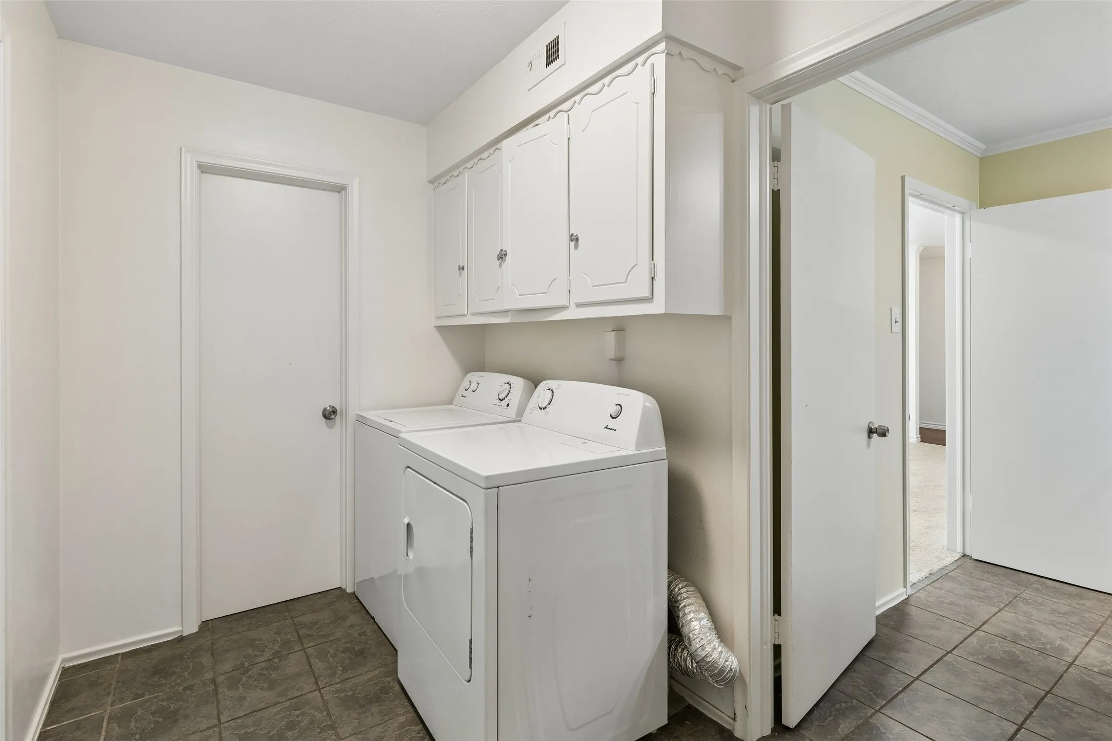 This utility room off the kitchen is home to a bathroom and multiple closets.