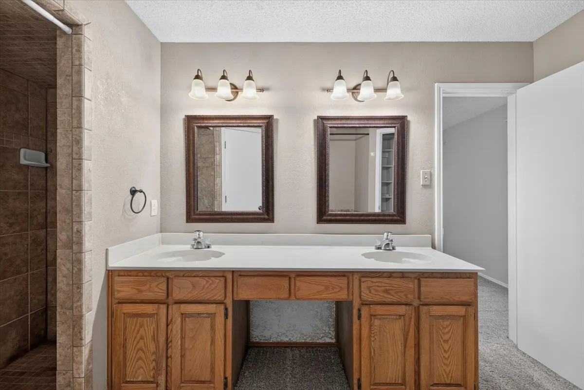 Double vanity with a white countertop and wood-finish cabinetry