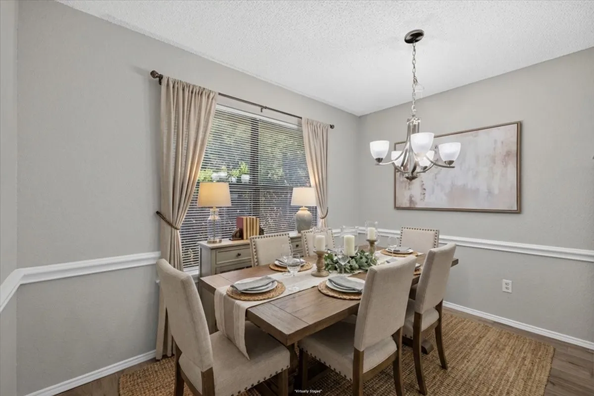 Dining area featuring a contemporary chandelier, crown molding, and chair rail detailing