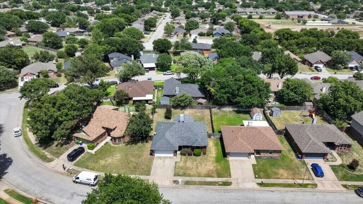 Aerial perspective showcasing a residential neighborhood with numerous mature trees