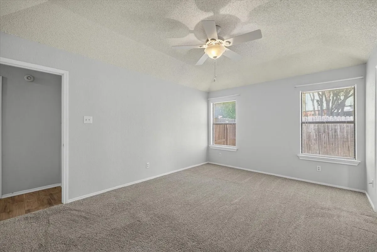 Spacious room featuring neutral carpeting and light gray wall paint