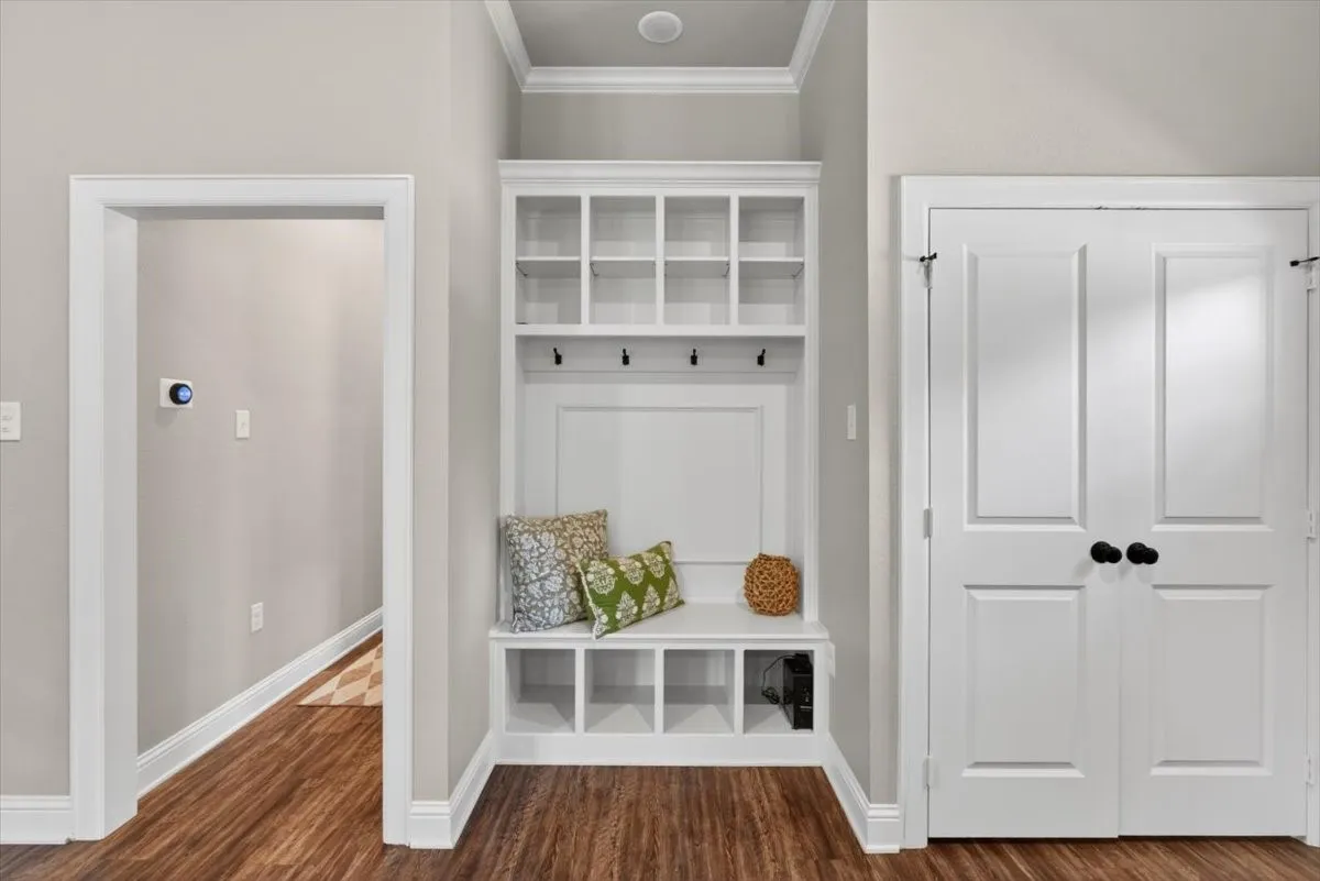 Built-in hall tree with upper cubbies, coat hooks, and bench seating with integrated storage