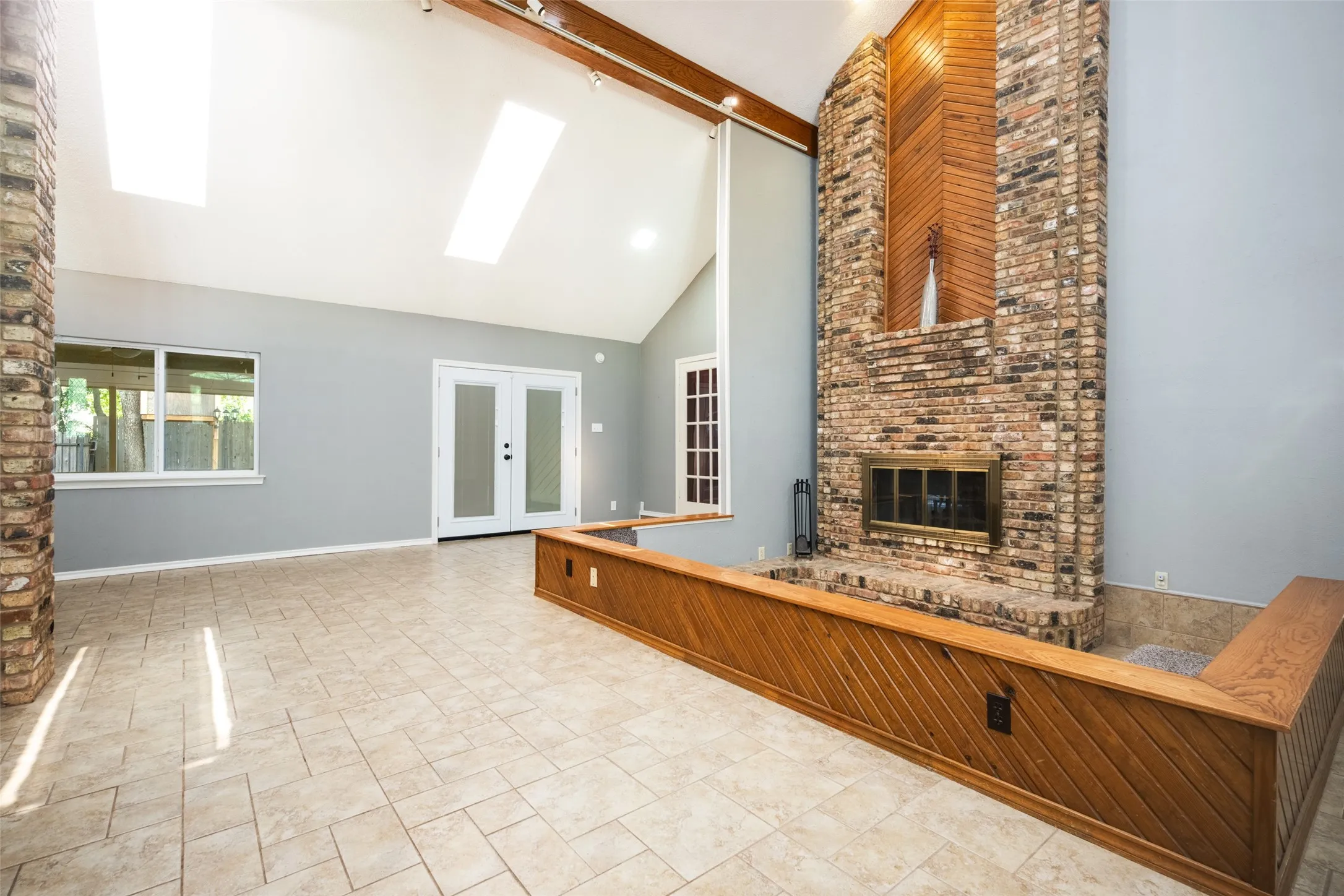 Vaulted ceiling with exposed wood beams and skylights
