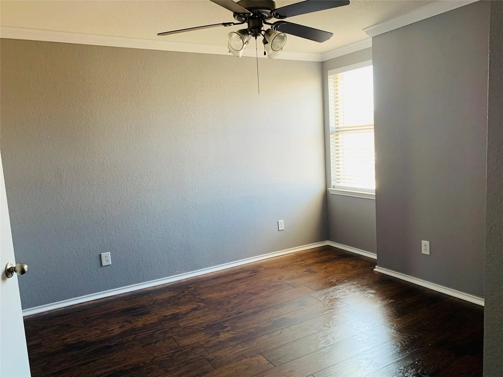 Unfurnished room featuring crown molding, wood-type flooring, and ceiling fan