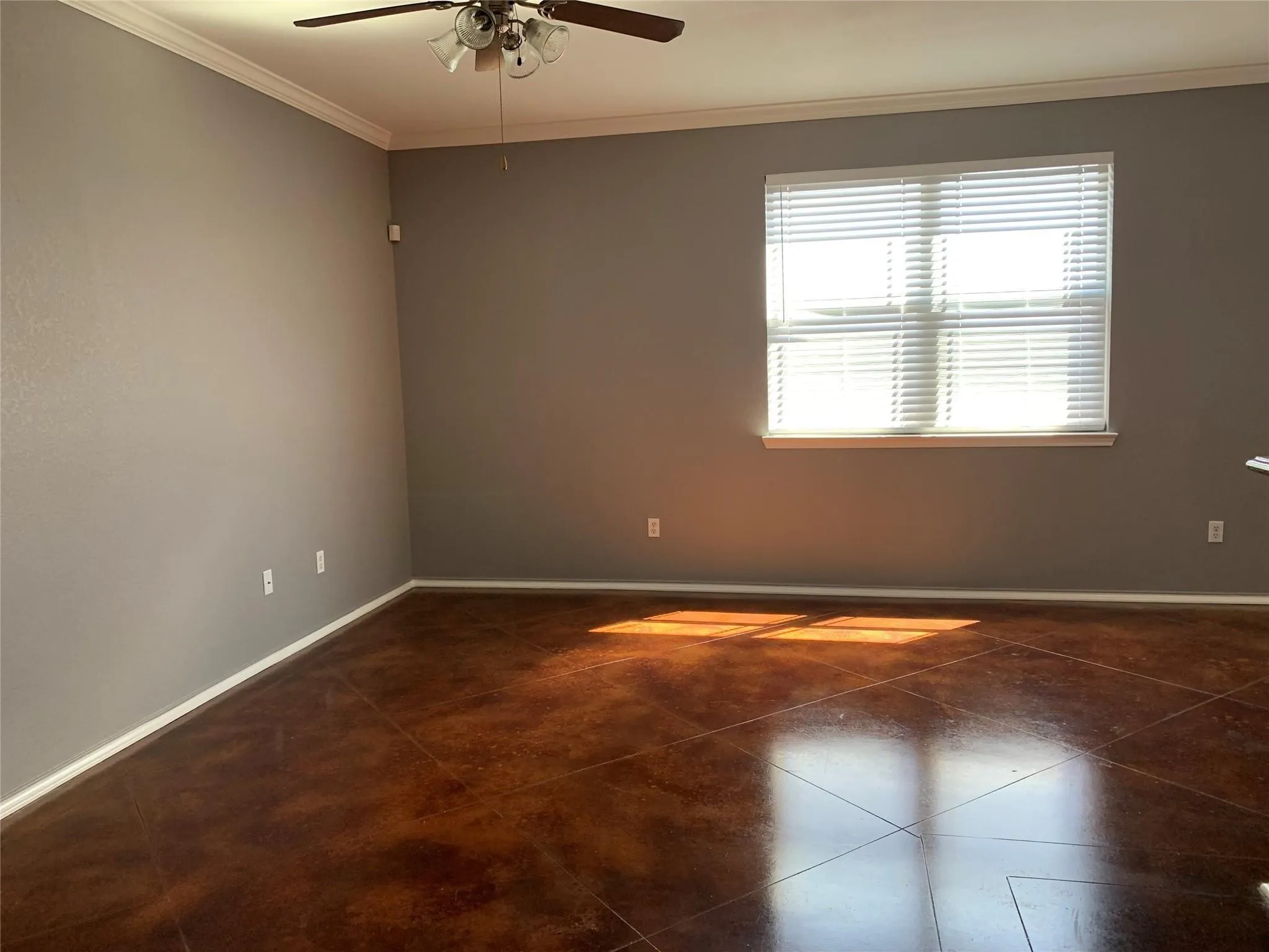 Unfurnished room with ornamental molding, dark tile flooring, and ceiling fan