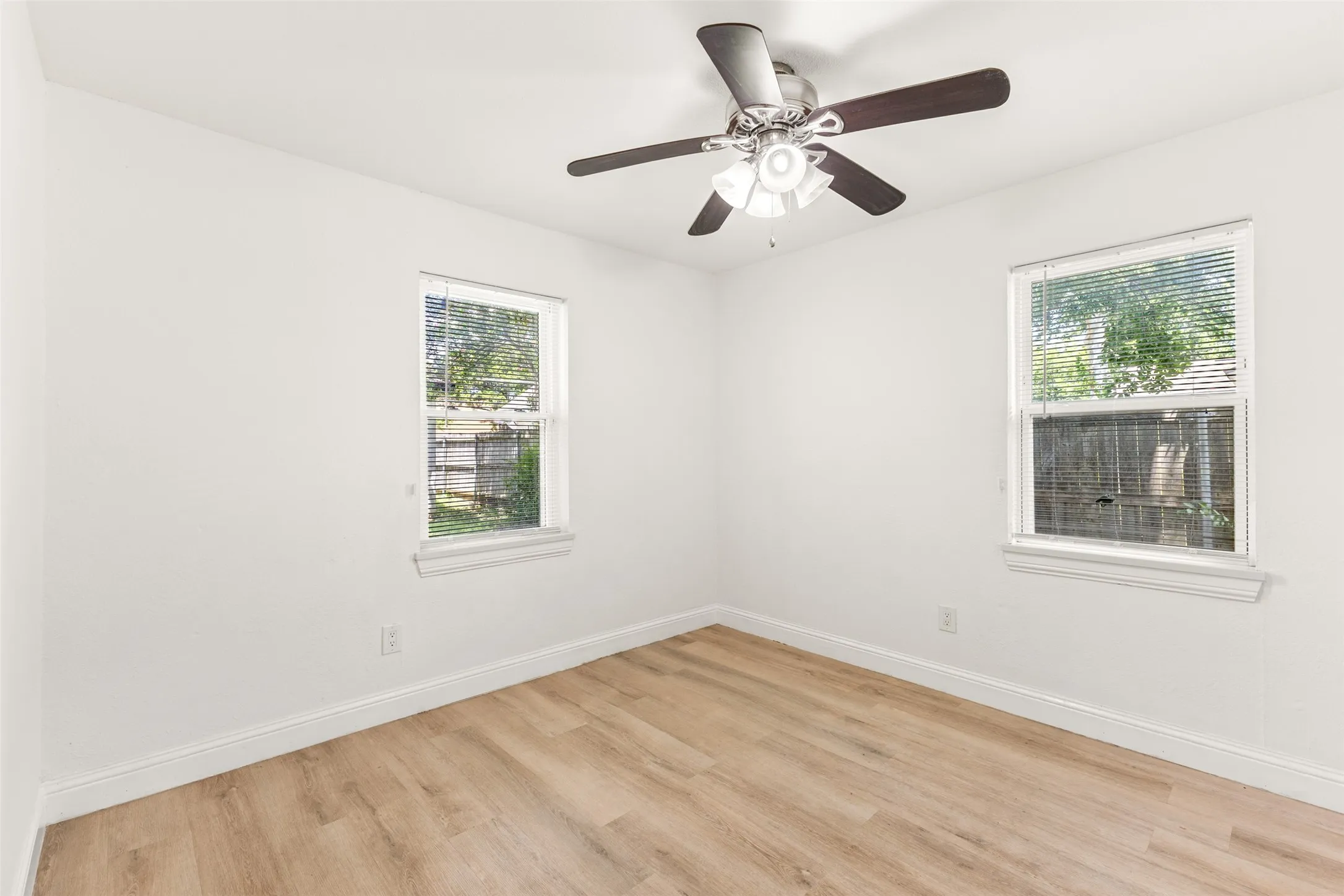 Third Bedroom featuring light wood-finish flooring, white walls, and a ceiling fan with integrated lighting