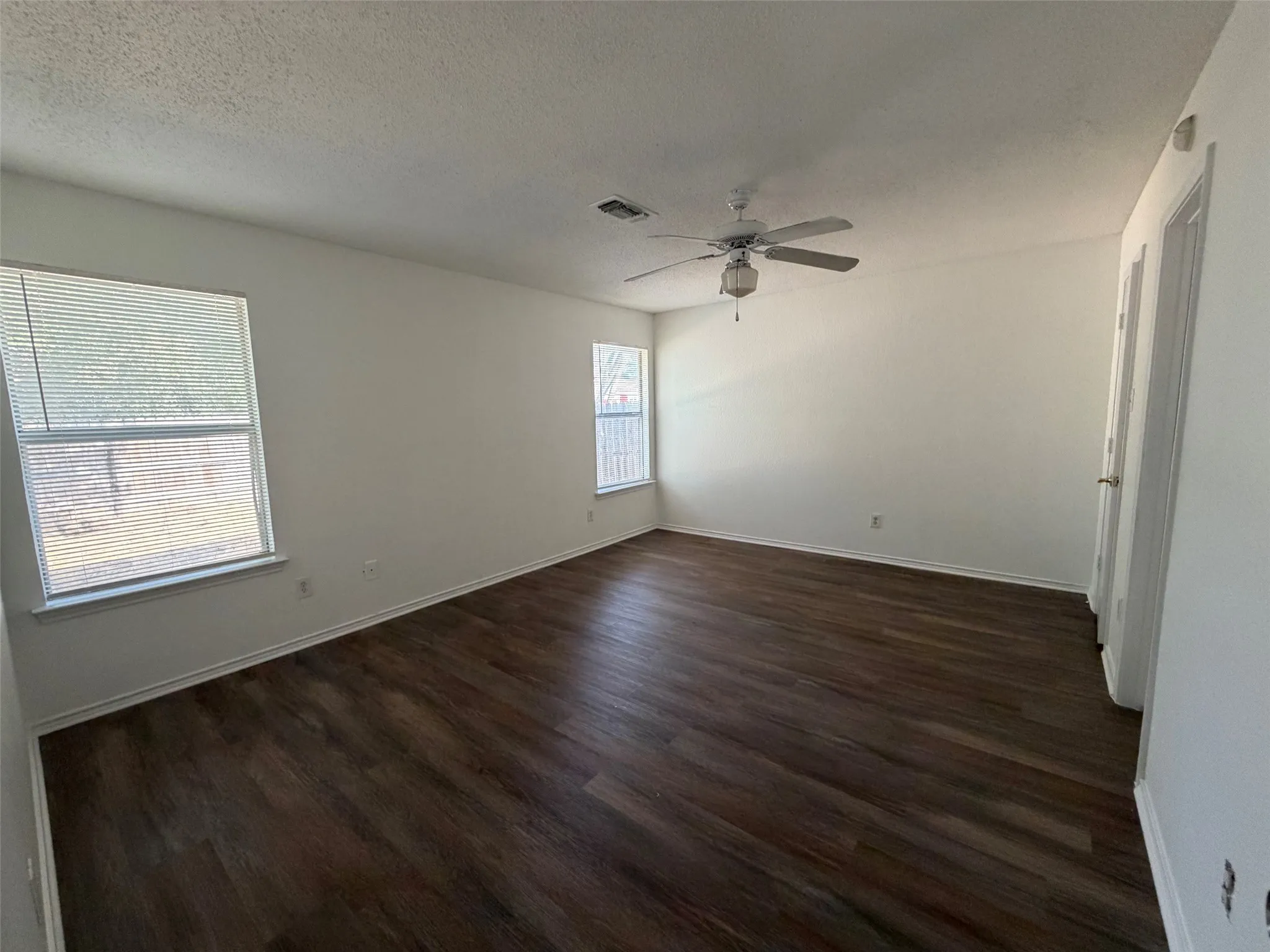 Large master bedroom with ceiling fan and walk in closet